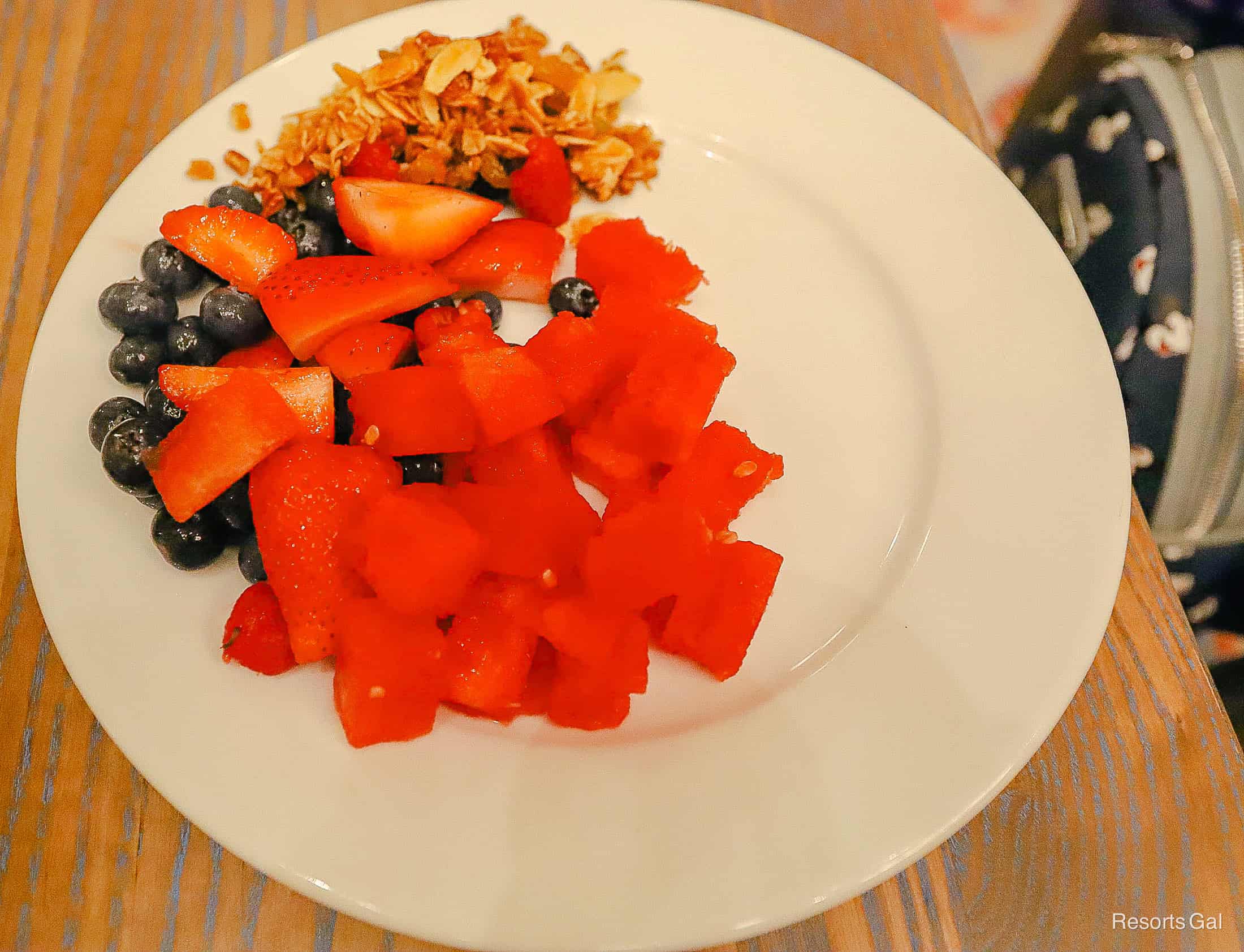 a plate with fruit, berries, and granola 