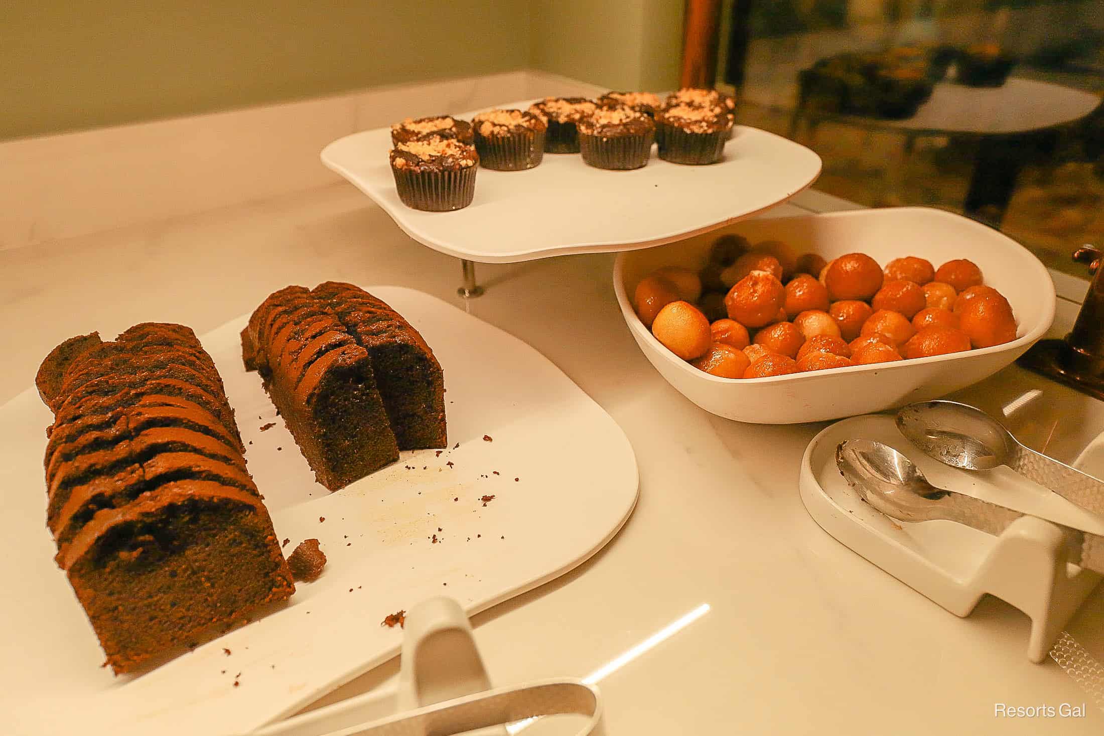 a station with chocolate slices of cake, chocolate muffins and doughnut holes 