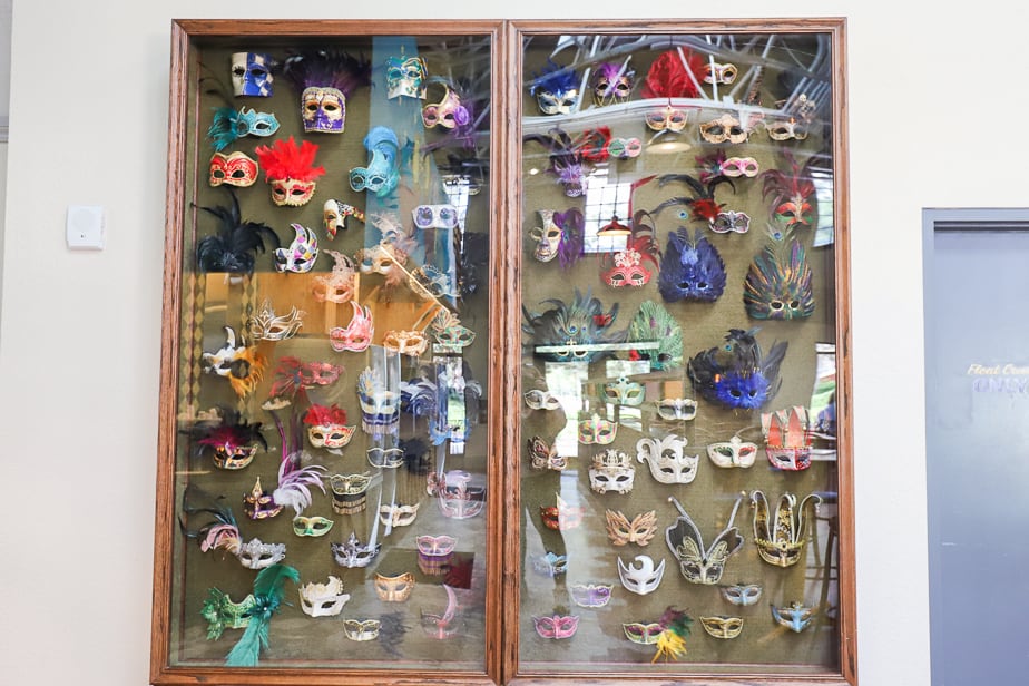 a shadow box full of decorative masks on display inside the quick service restaurant at Disney's Port Orleans French Quarter 