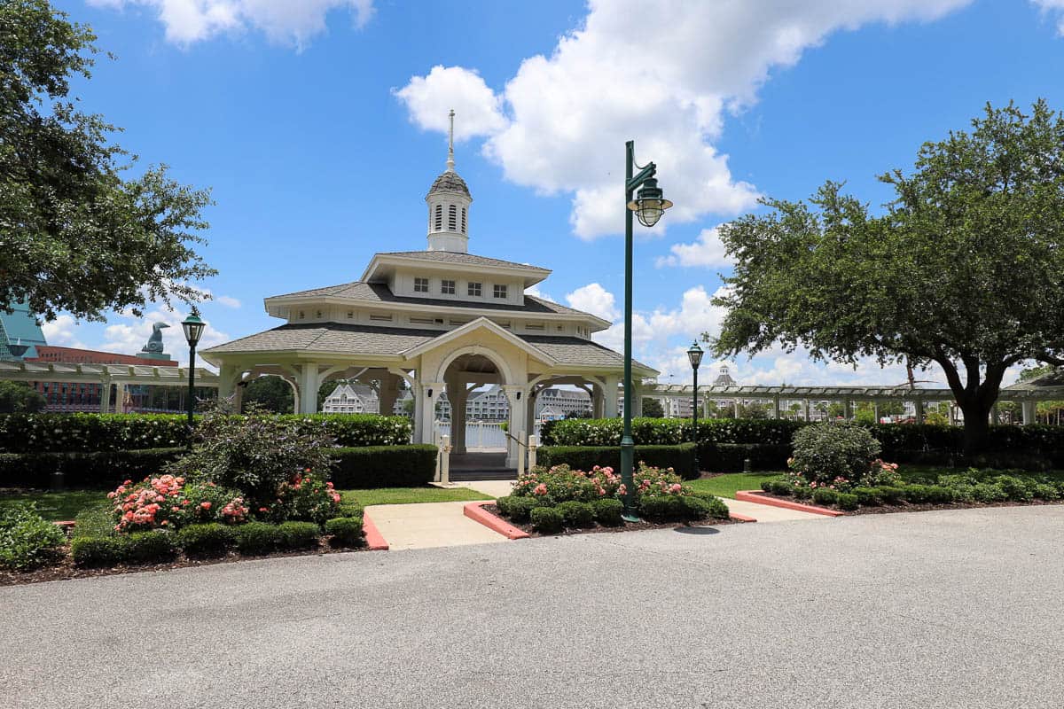 a gazebo with pink roses along the walkway to Epcot