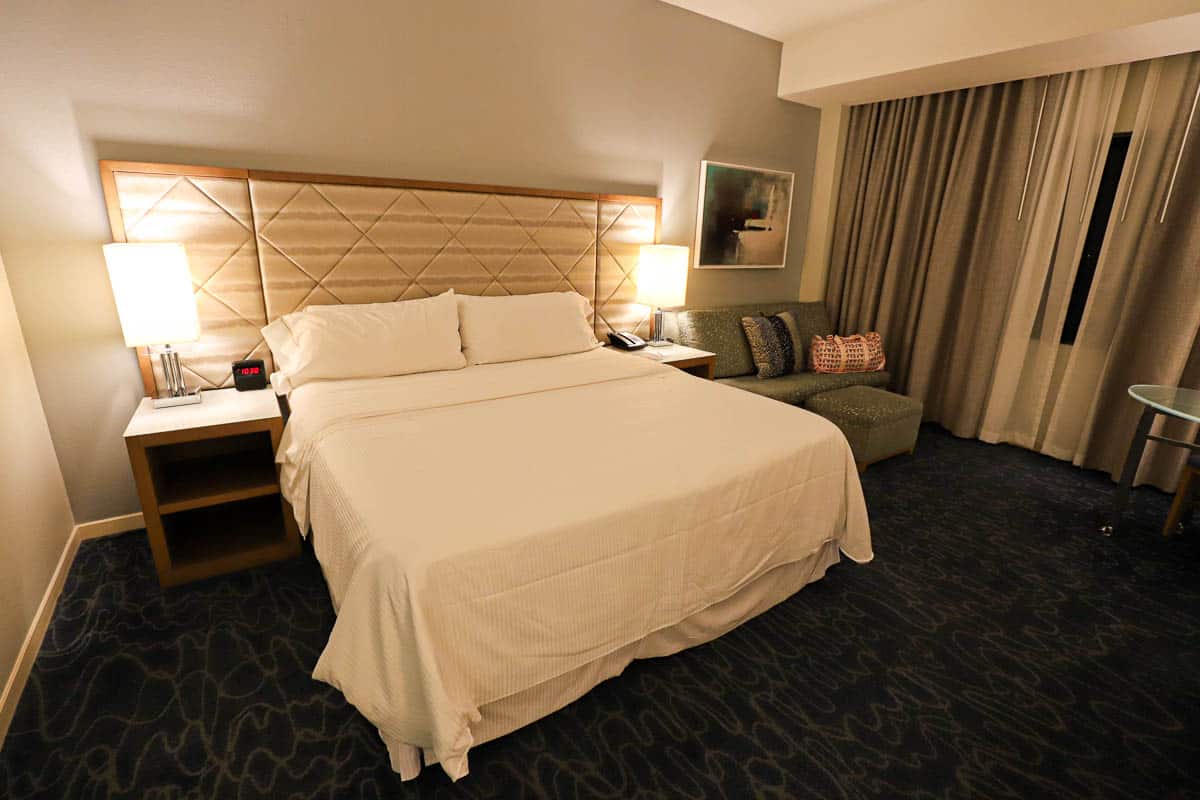 a king size bed in a hotel room with carpet and curtains