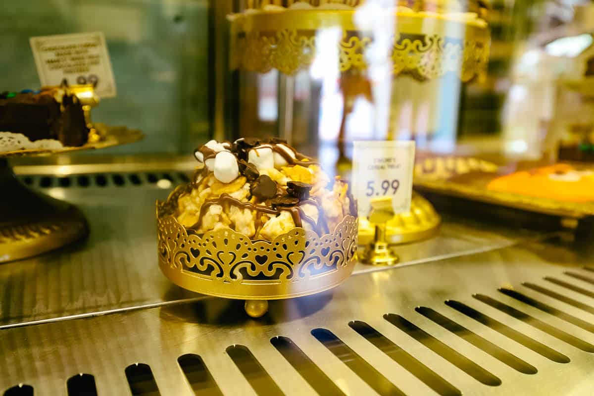 a sweet treat in the dessert case topped with marshmallows and chocolate drizzle 