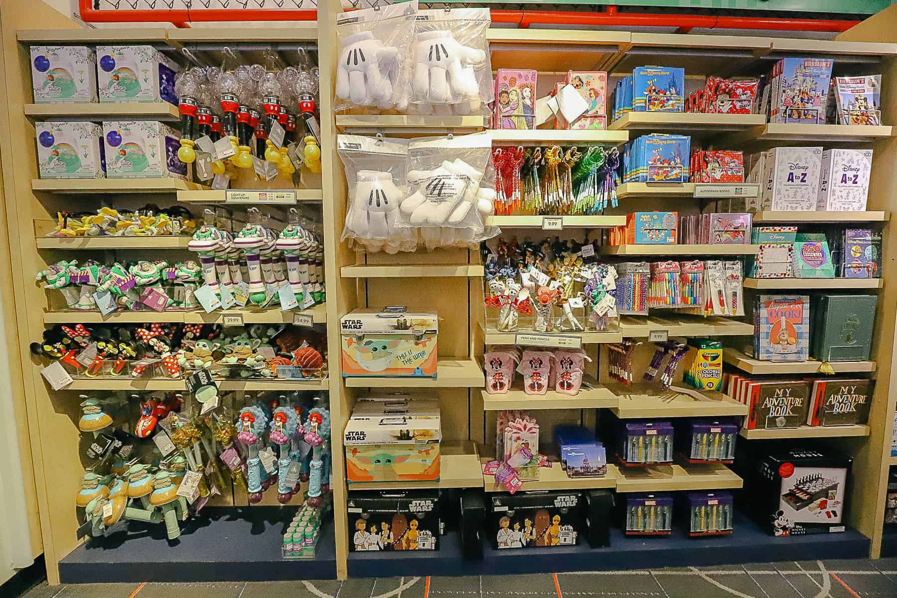 a wall with Mickey hands, character autograph books, albums, and pens 