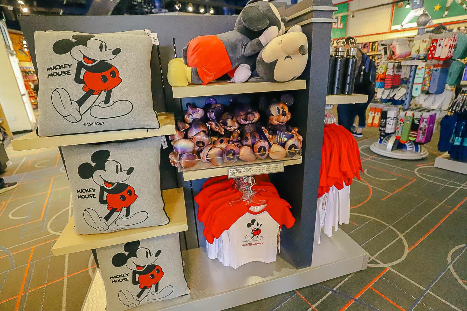a display with Mickey Mouse merchandise like pillows and shirts 