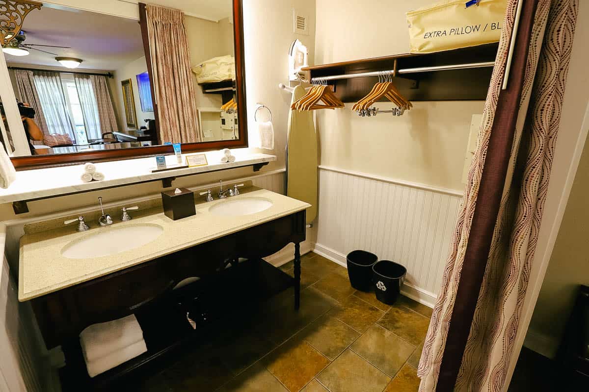 a guest bath with two sinks, a place to hang items (open closet) and a ledge for storage above the sink 