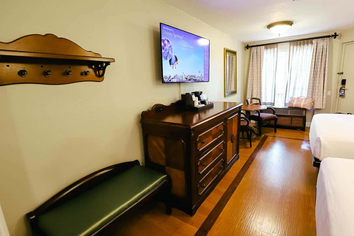 a shelf with a place to hang items and a bench in the room at Disney's Port Orleans French Quarter 