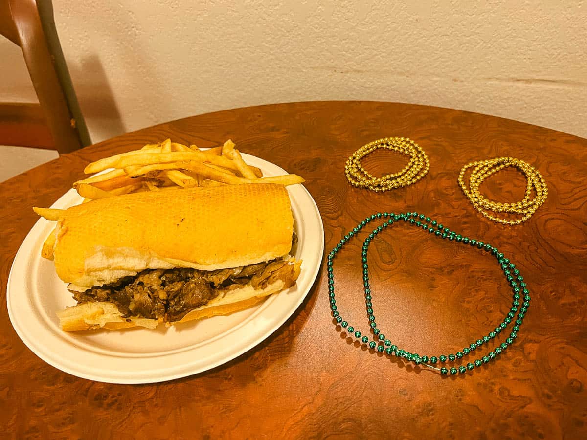 a prime rib roast beef sandwich from Sassagoula Floatworks and Food Factory with beads shaped to look like Mickey beside it 
