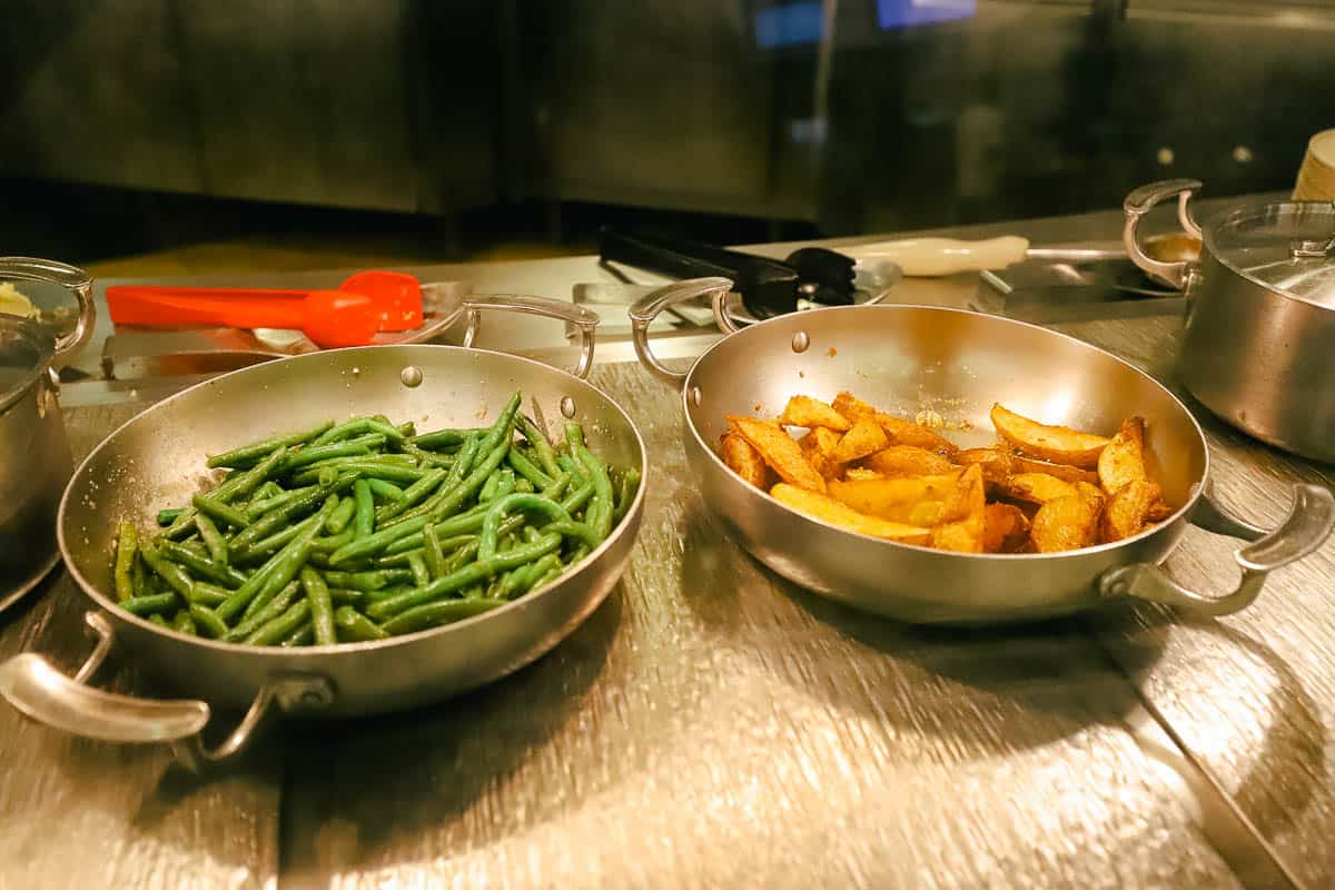 a platter with green beans and roasted potatoes 