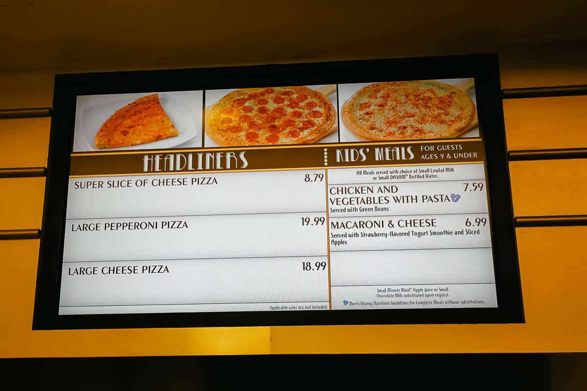 a menu board with slices of pizza and entire pizzas at All-Star Movies Resort 