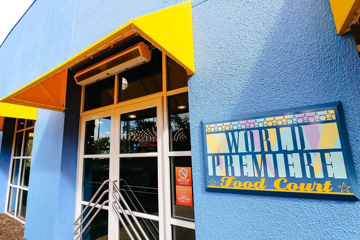 the side entrance to World Premiere Food Court with blue paint and a yellow awning 