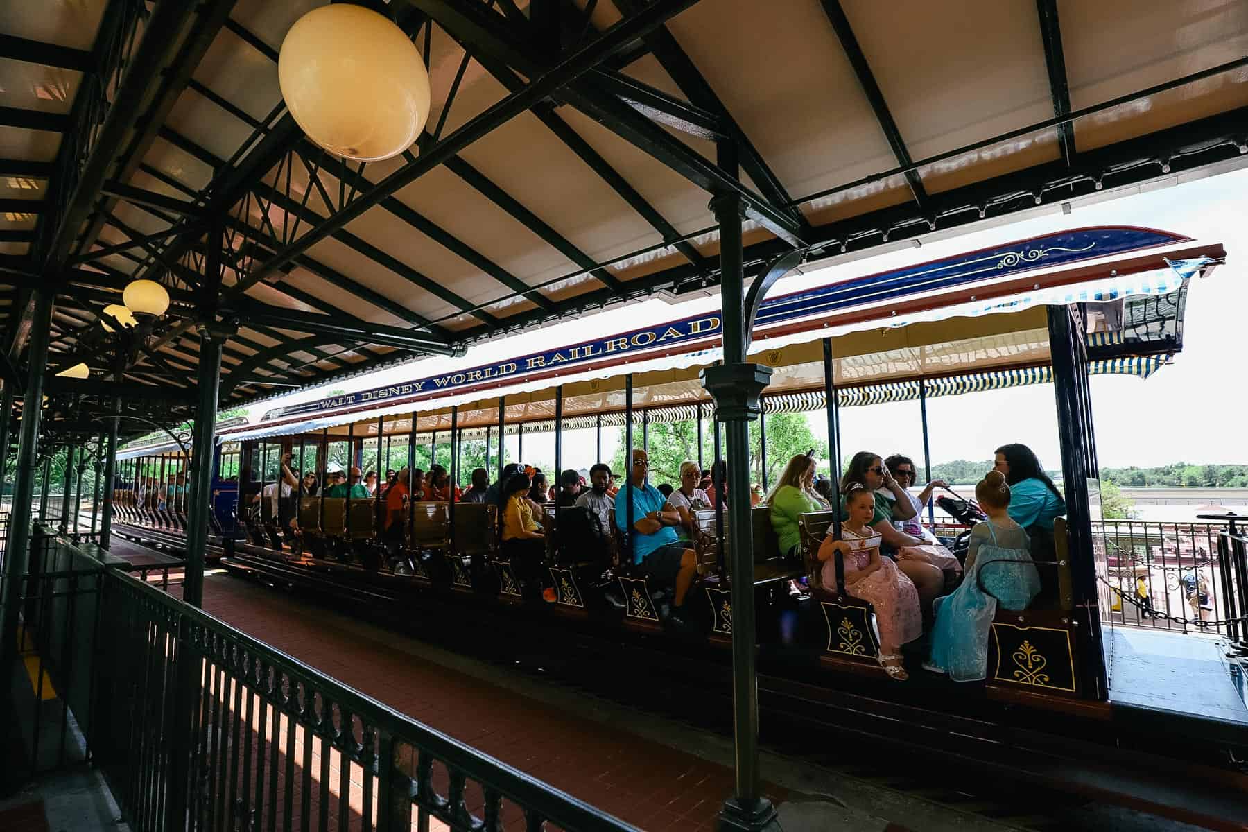 guests sitting on a train car waiting on the Walt Disney World Railroad