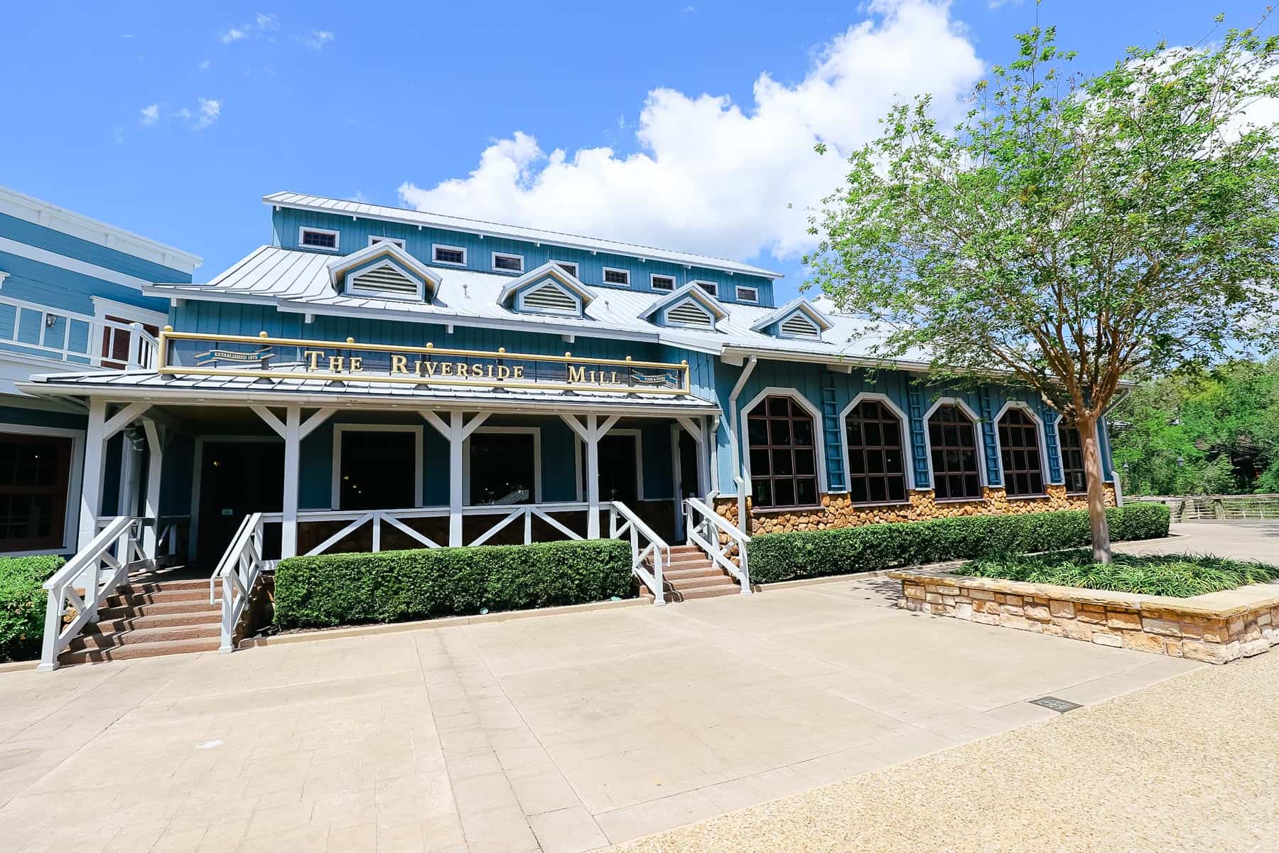 The Riverside Mill Food Court entrance at Port Orleans Riverside, a blue building with metal roof.