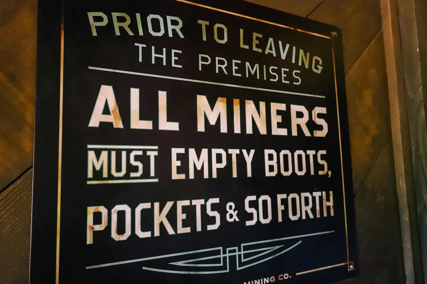 Signs warns guests that all miners must empty boots, pockets, and so forth. 