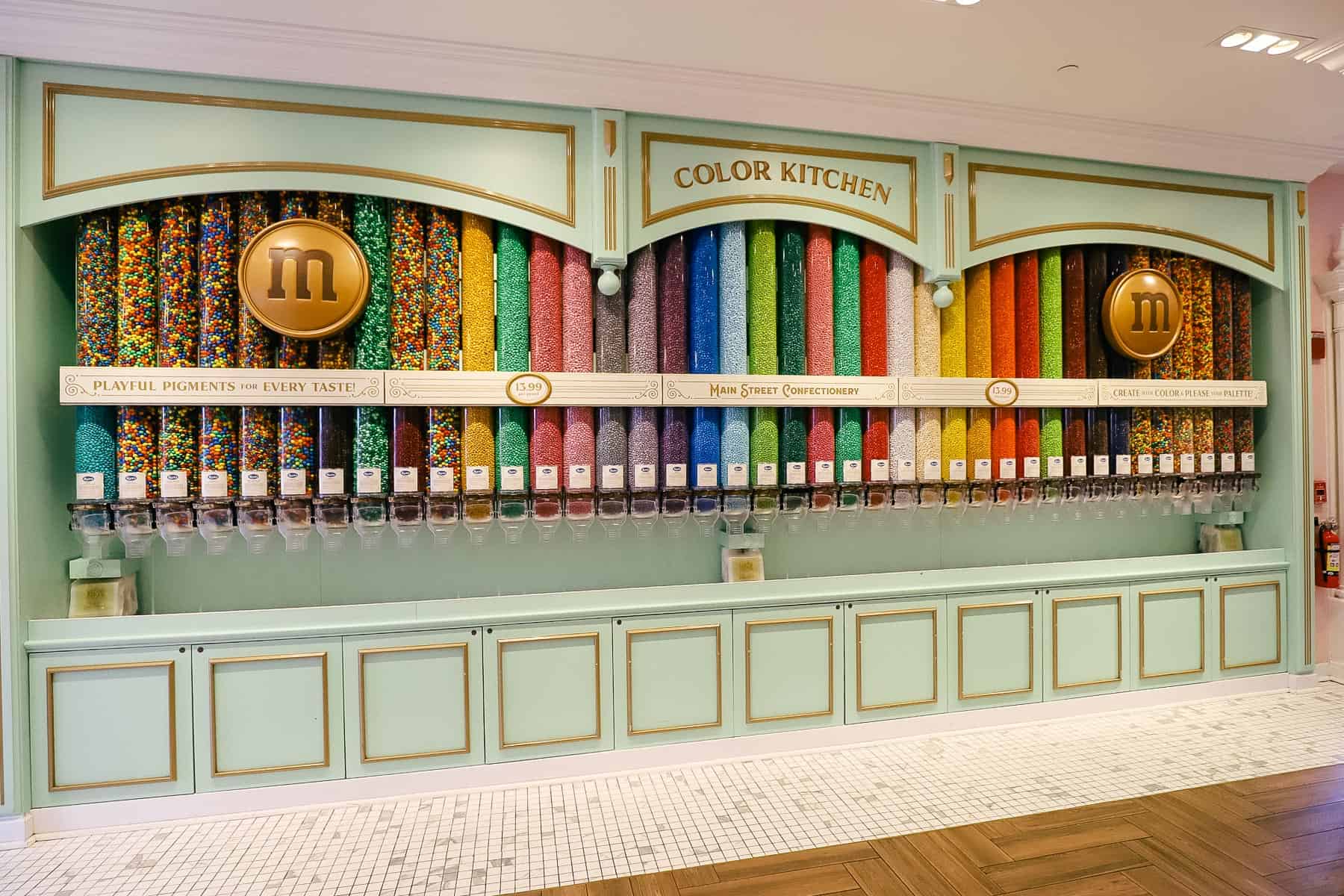 a wall with long tubs of M&M's making a decorative display inside the Main Street Confectionery at Magic Kingdom