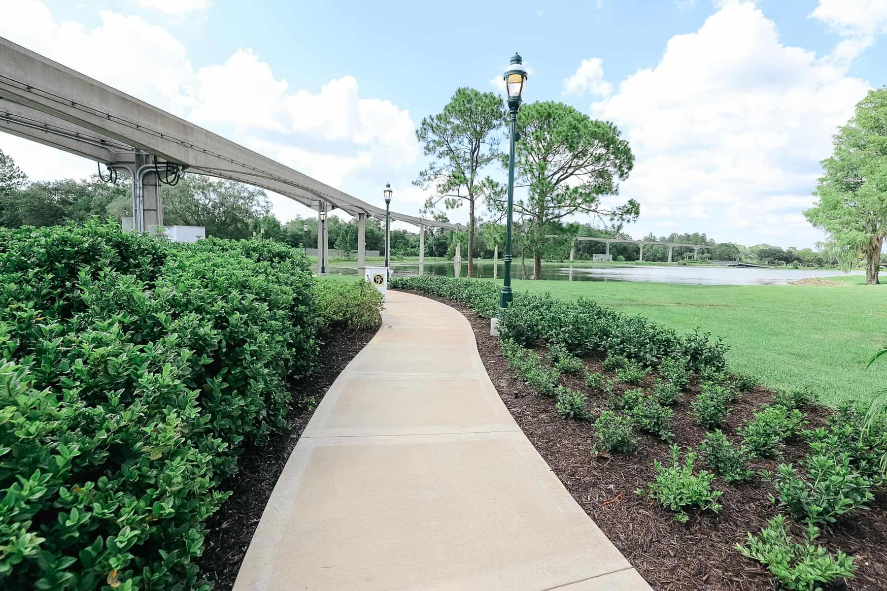 the walking path with shrubbery around it and monorail track 
