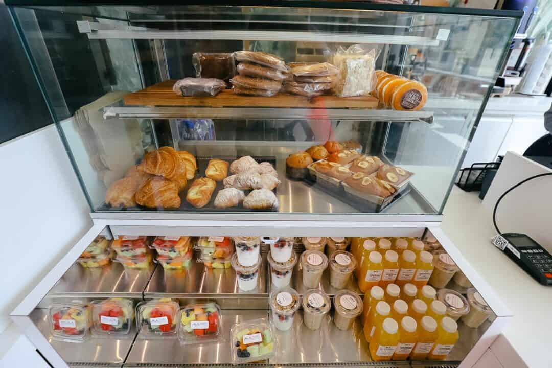 A pastry case with croissants, banana bread, brownies, and cookies. 