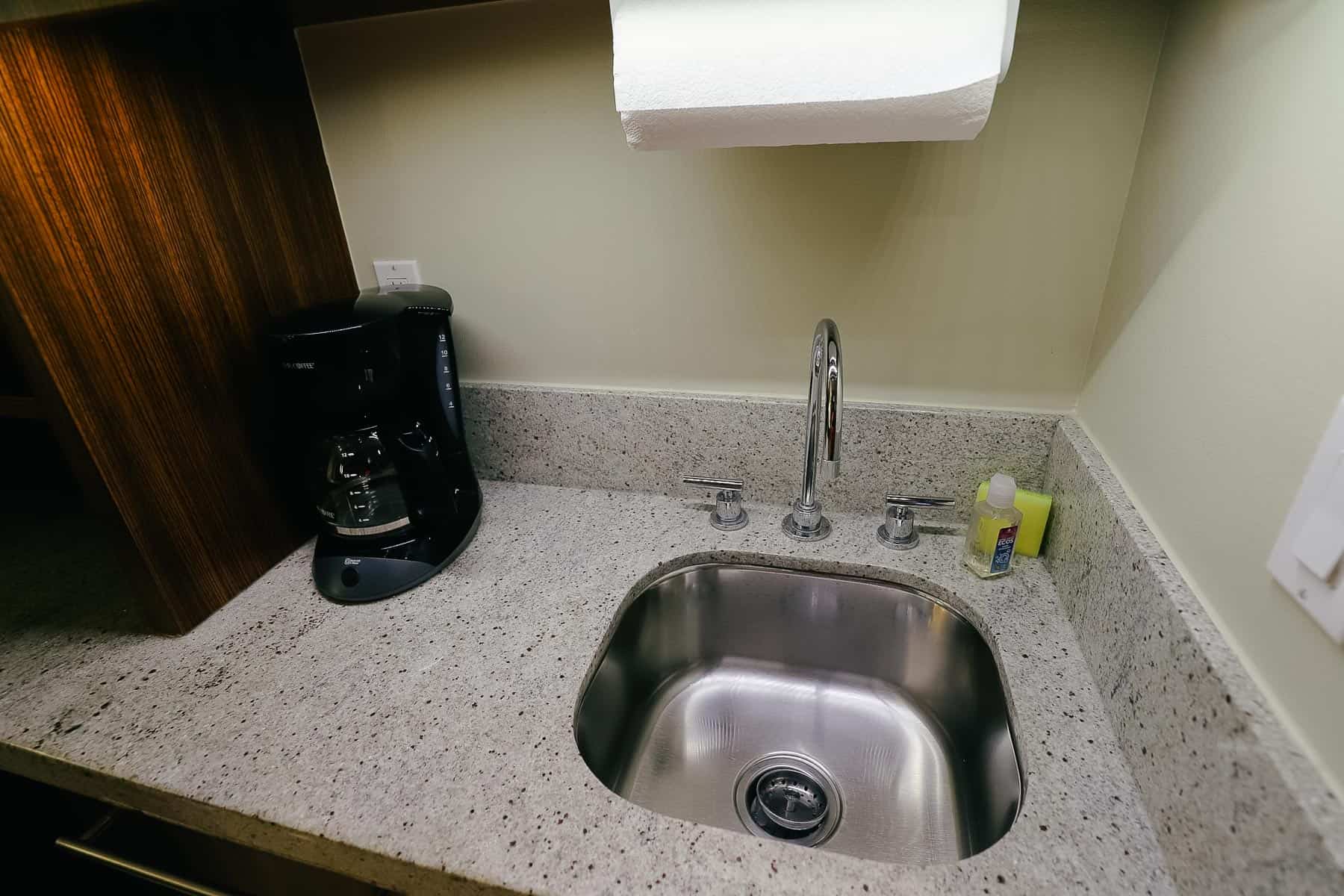 a small sink with a coffee maker
