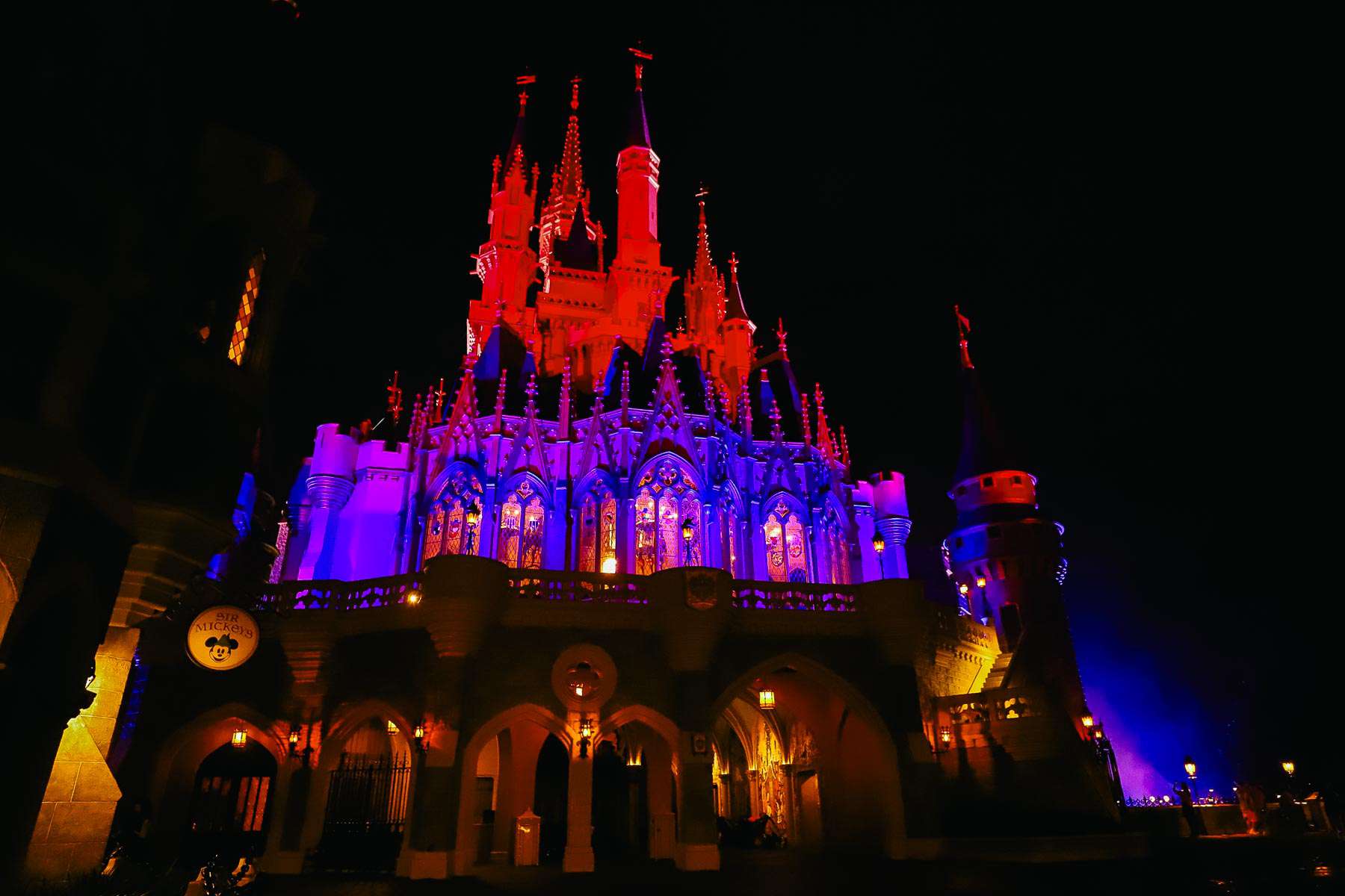 the back side of Cinderella Castle lit up in red and blue
