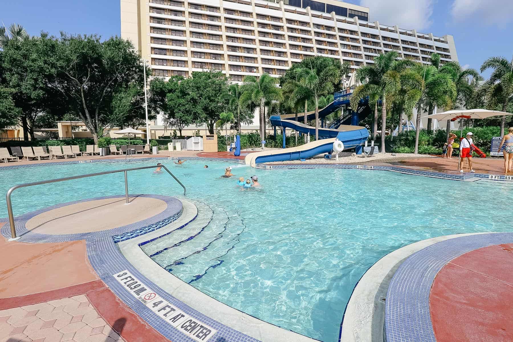 a view from the back of the pool with the water slide 