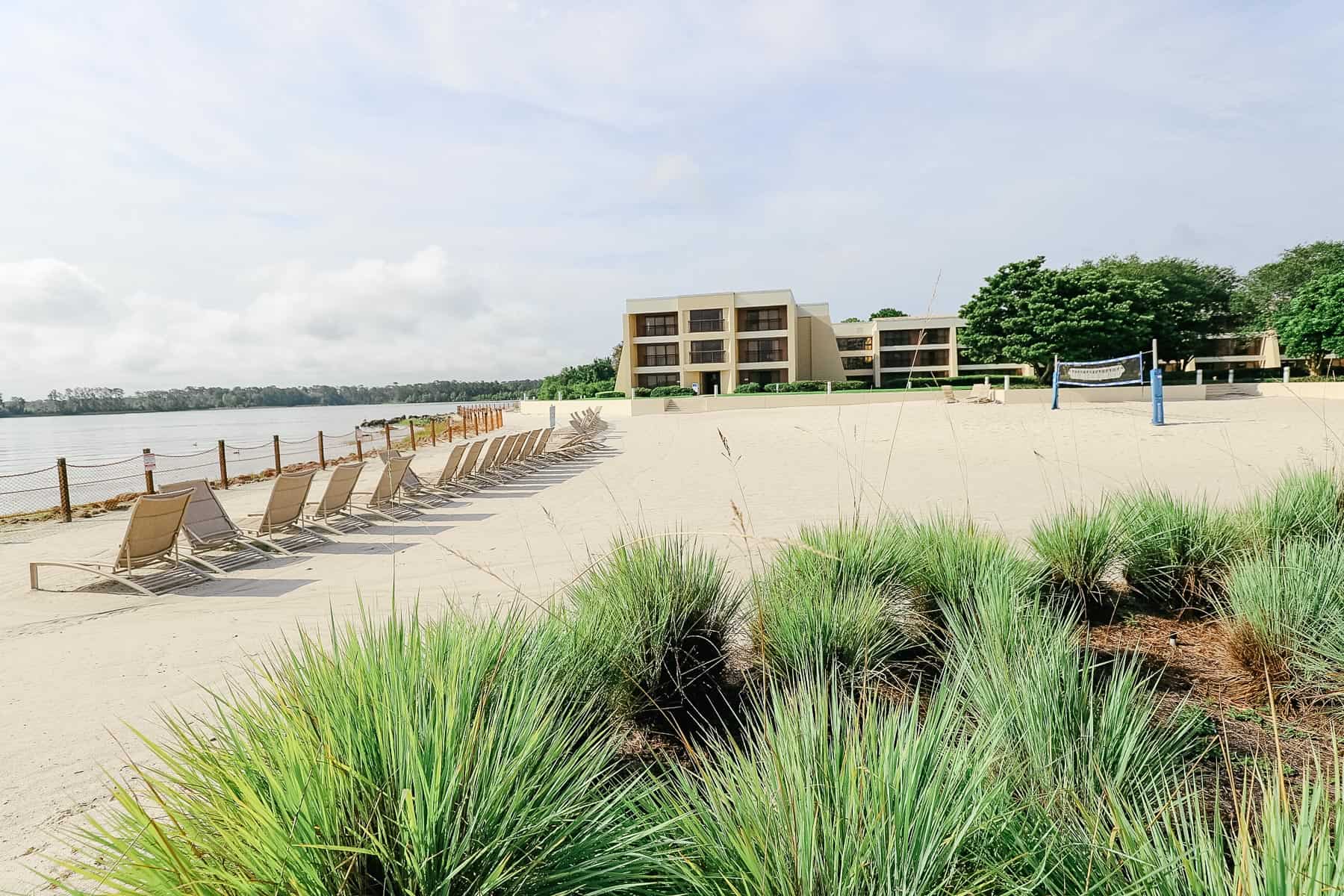 a white sand beach with lounge chairs and a volleyball net that has the monorail printed on it 