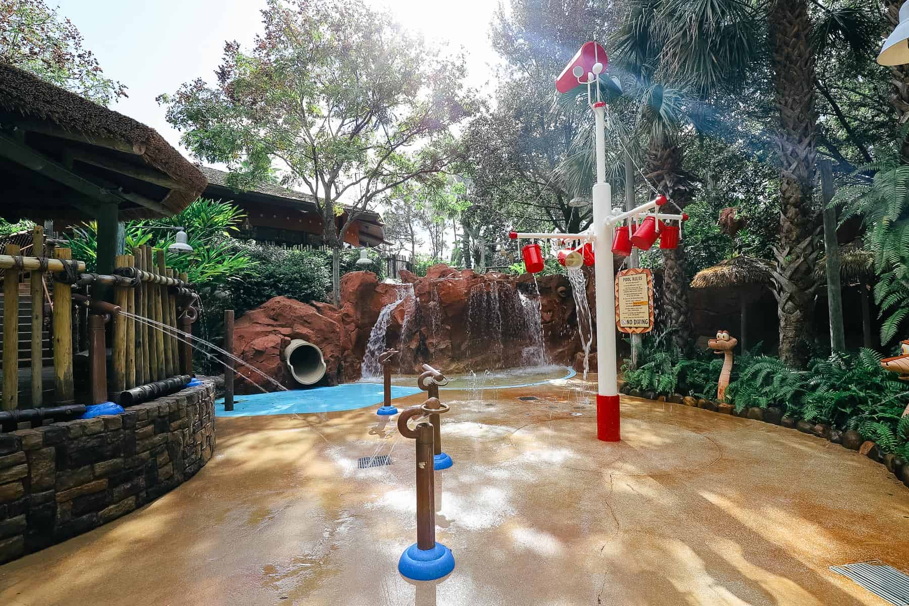 sunlight streaming down on the children's water play area 