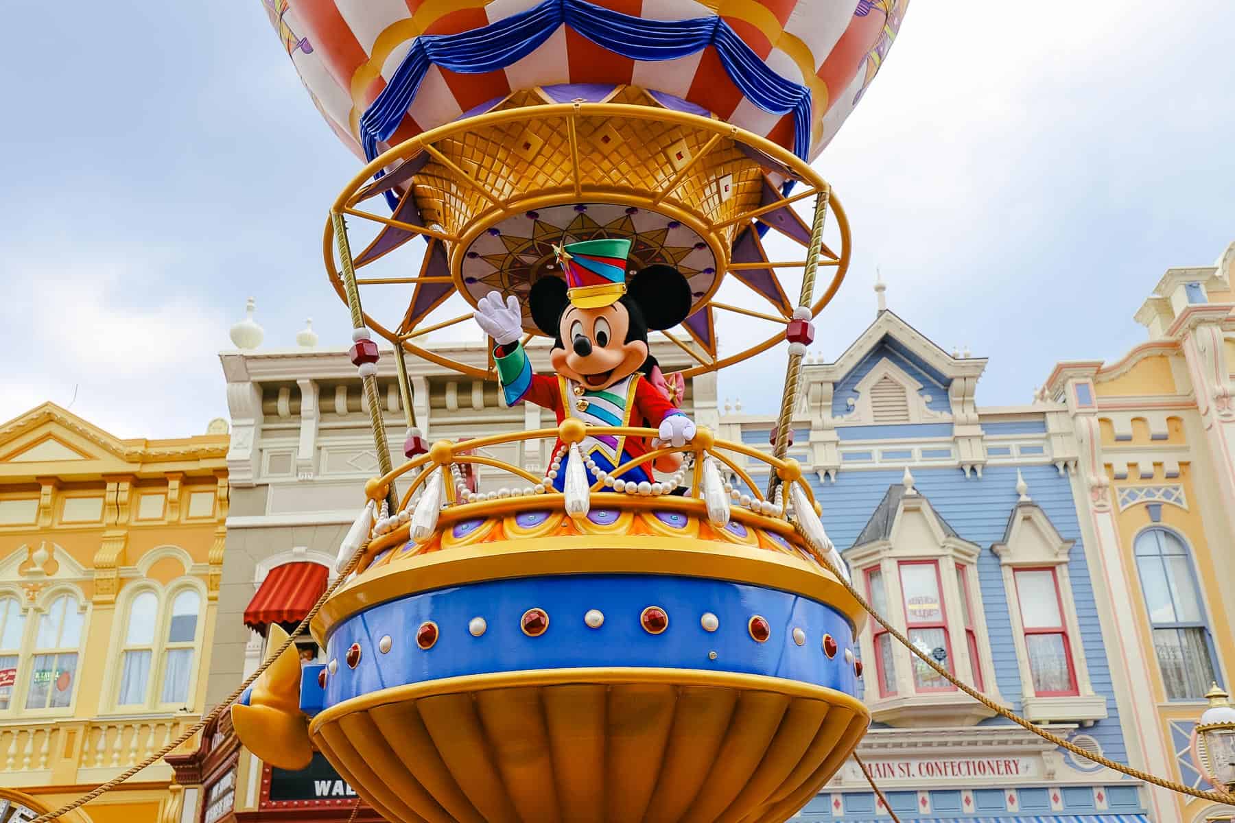 Mickey Mouse waving from his float in the Magic Kingdom parade. 