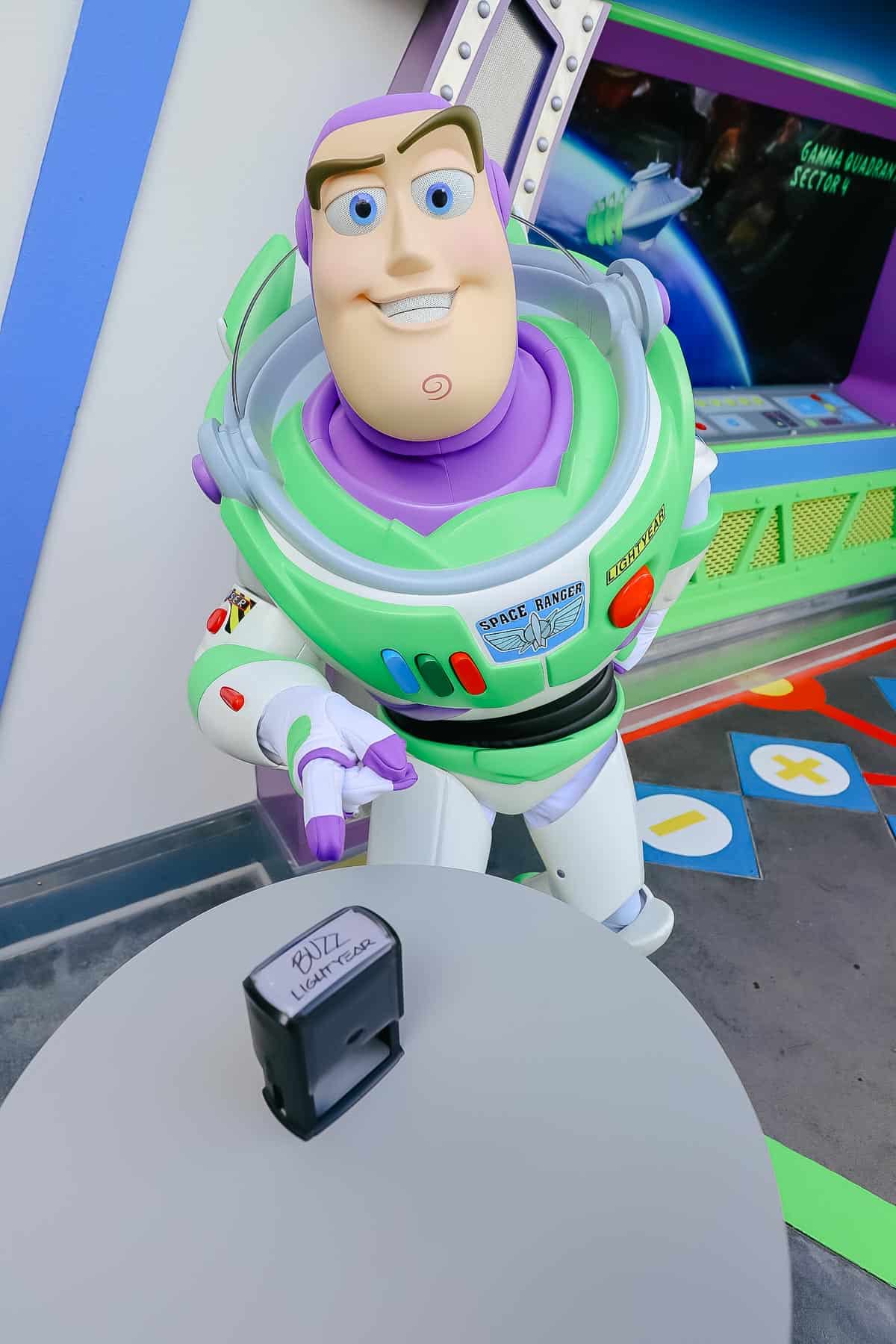 Buzz pointing to his autograph stamp at Magic Kingdom. 
