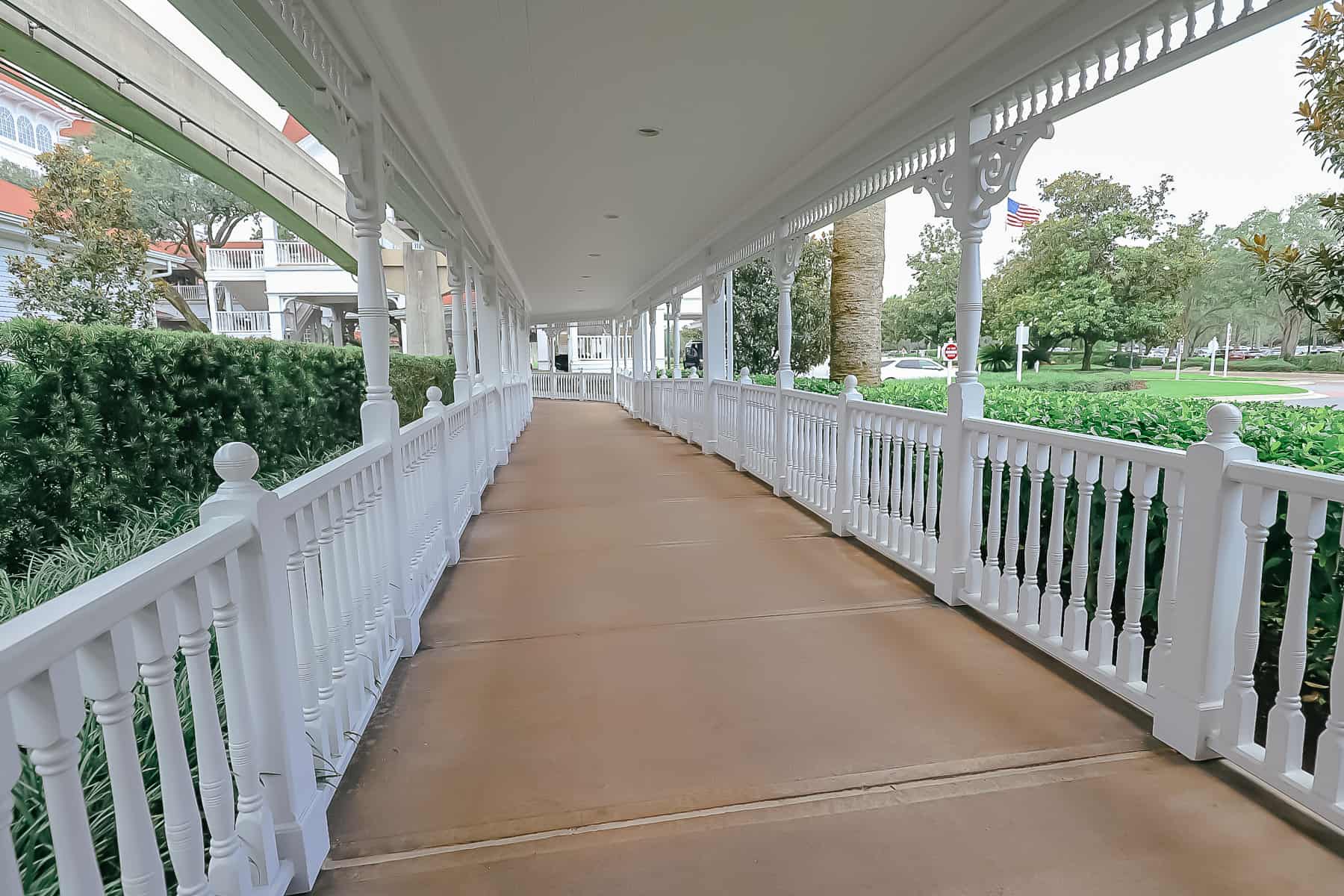 a walkway with white railings leading to the bus stop at Grand Floridian 