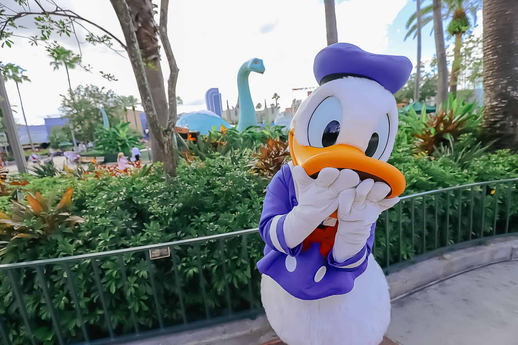 Donald with a laugh expression with hands over mouth. 