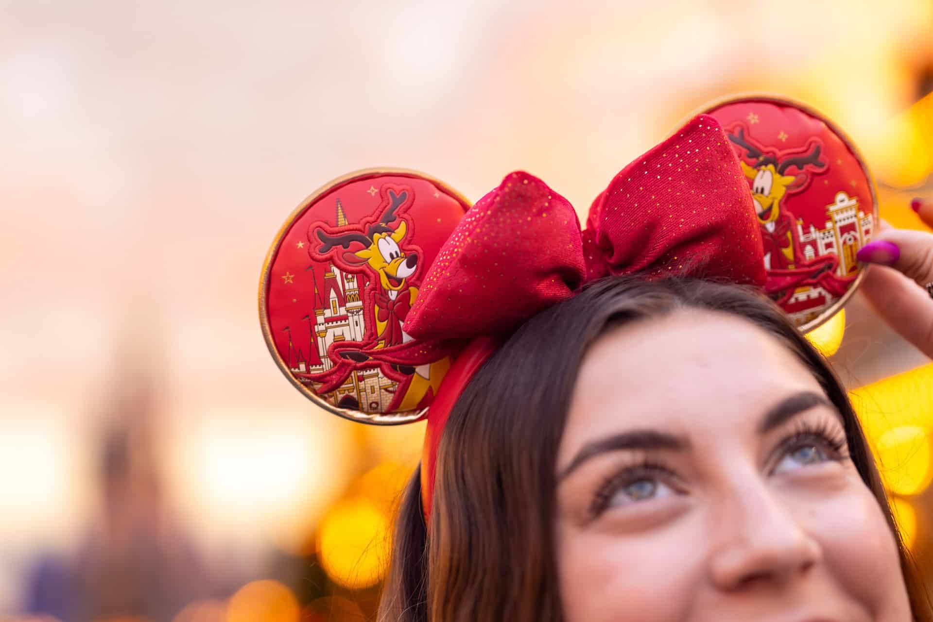 a pair of Minnie Ears with a red bow and yellow reindeer 