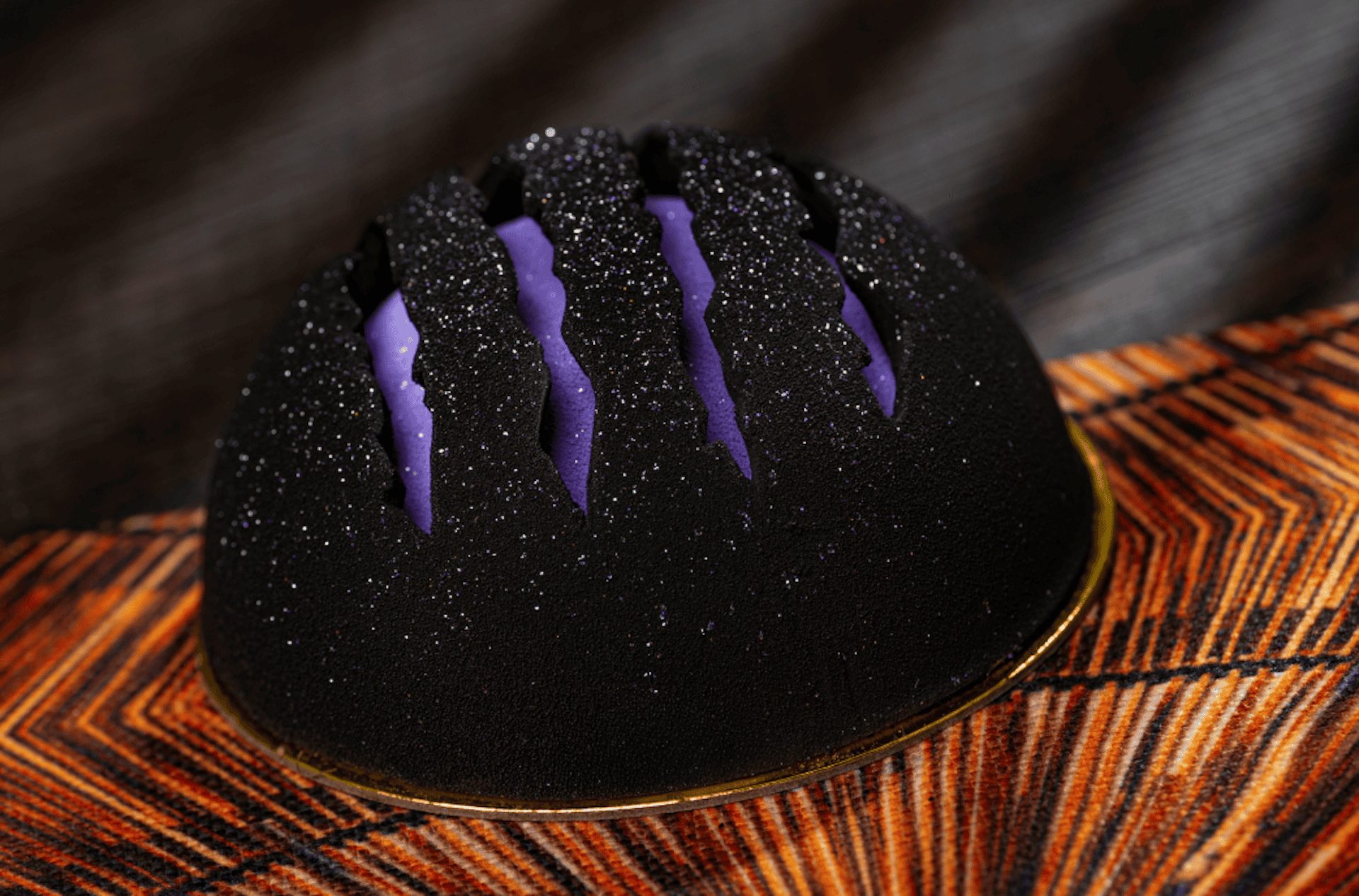 a black cake with mousse and purple stripes 