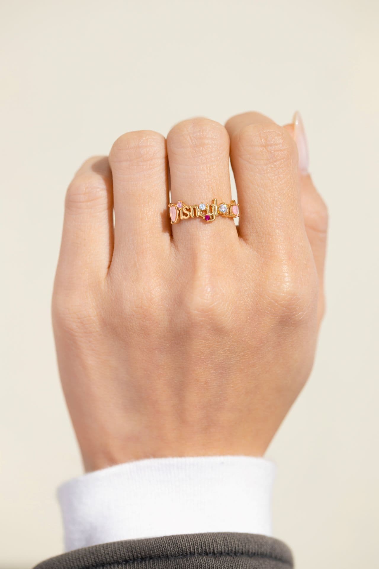 a hand modeling a ring with the Disneyland logo 
