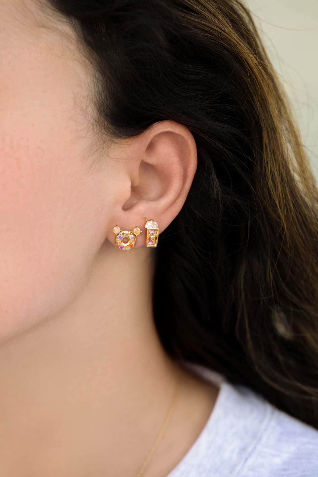a model wearing a Mickey-shaped doughnut earring and a shake 