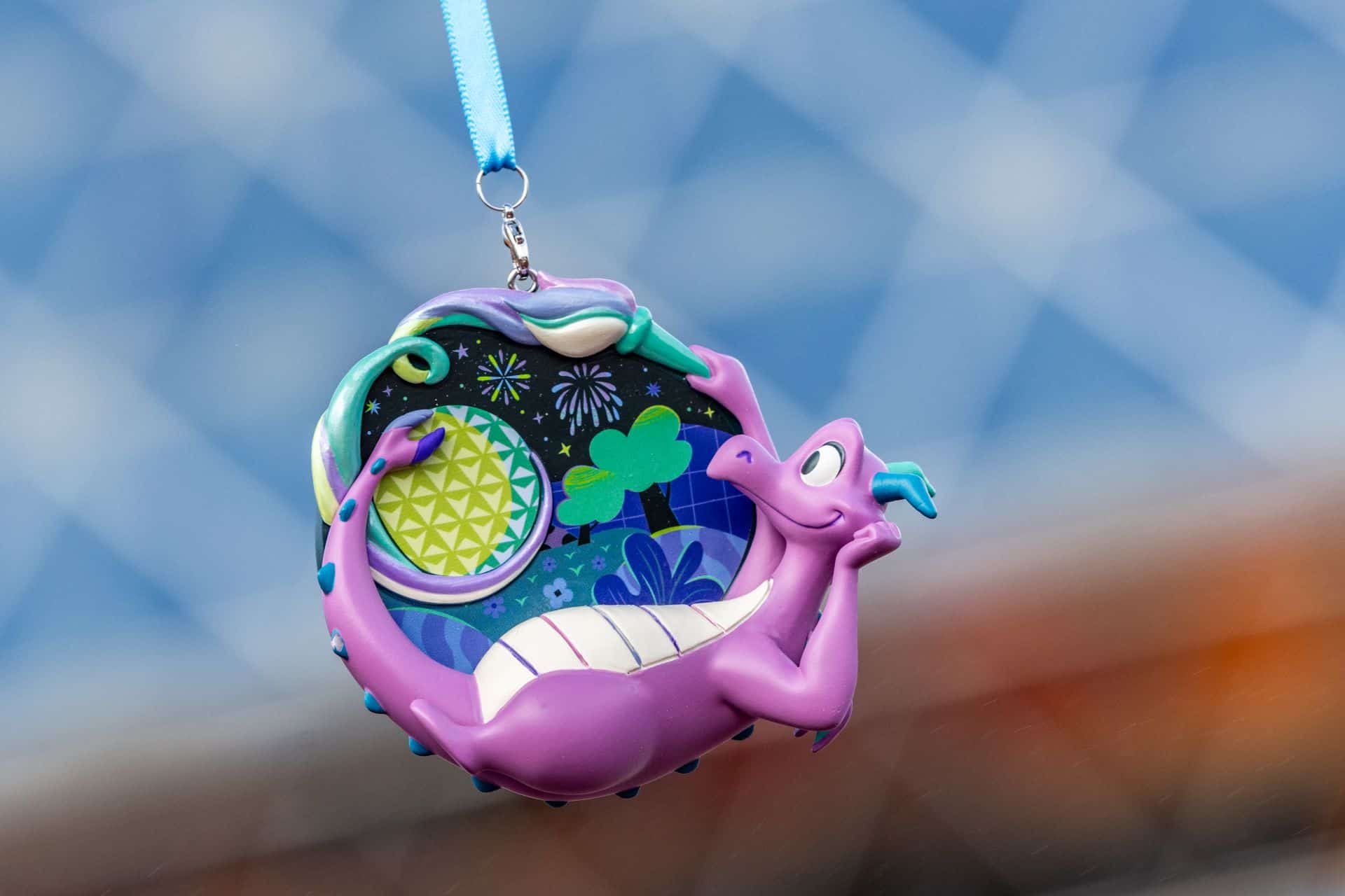 an ornament featuring Figment as he stares into the night sky and fireworks 
