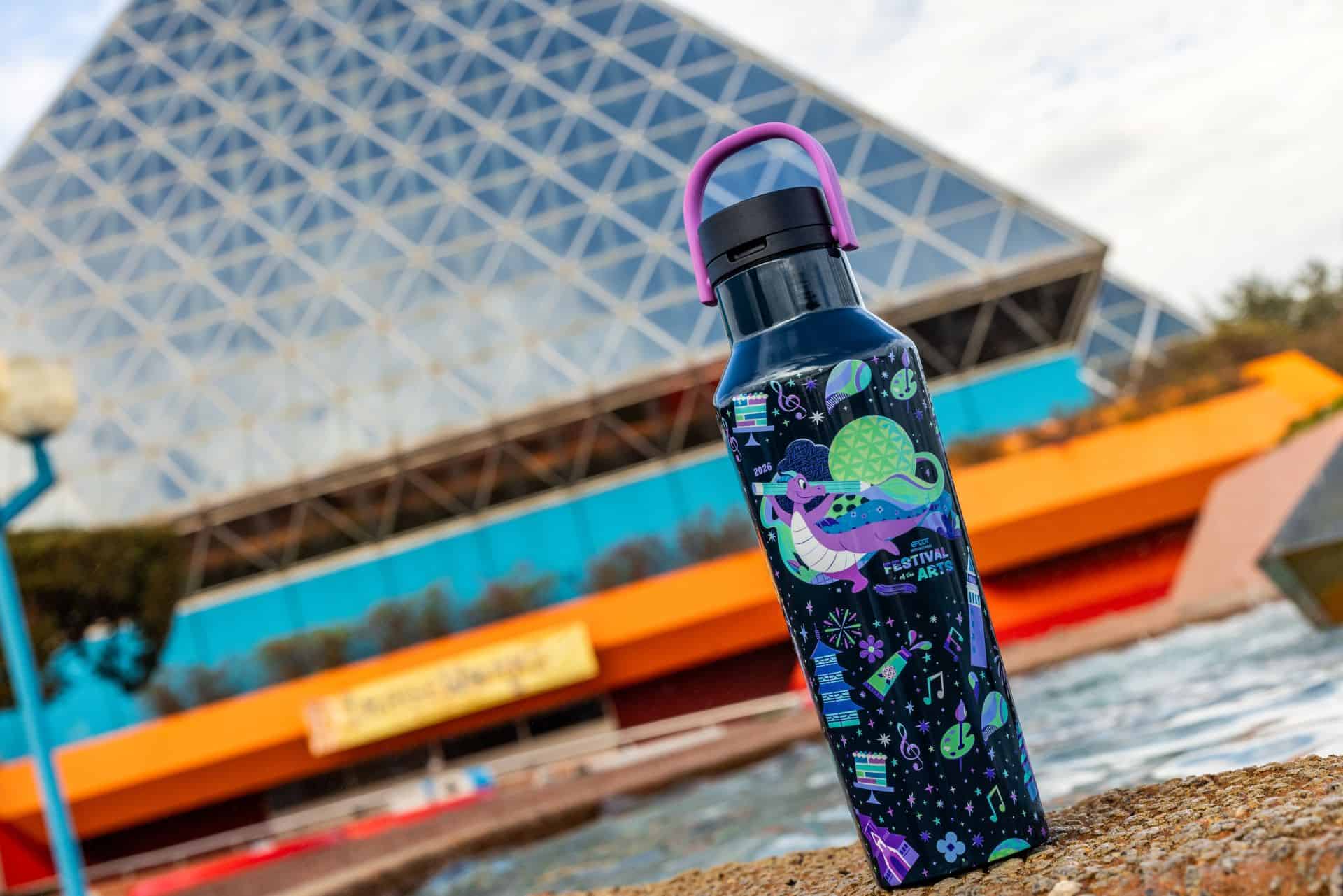 a Figment water bottle in front of the Imagination Pavilion at Epcot 