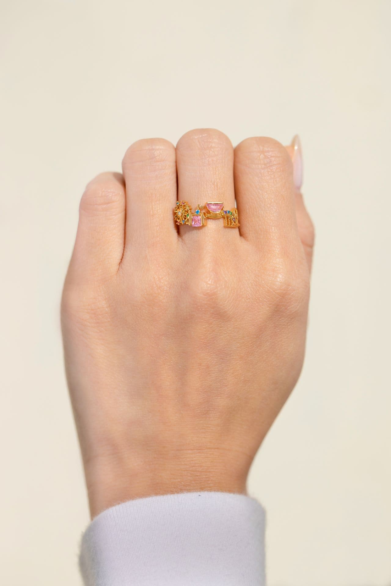 a hand modeling a ring with the Disneyland icons 