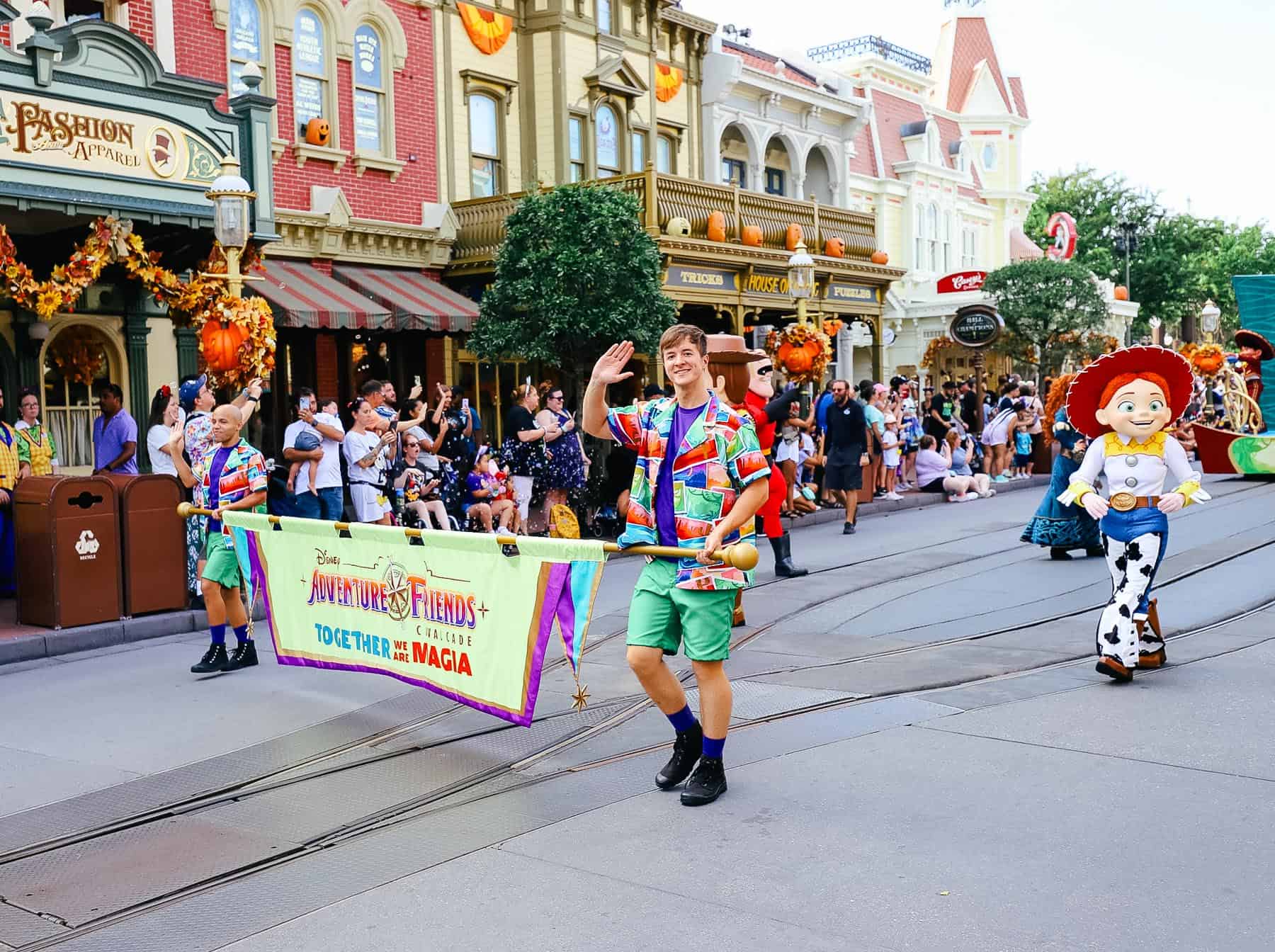 cast members carrying the Adventure Friends banner 