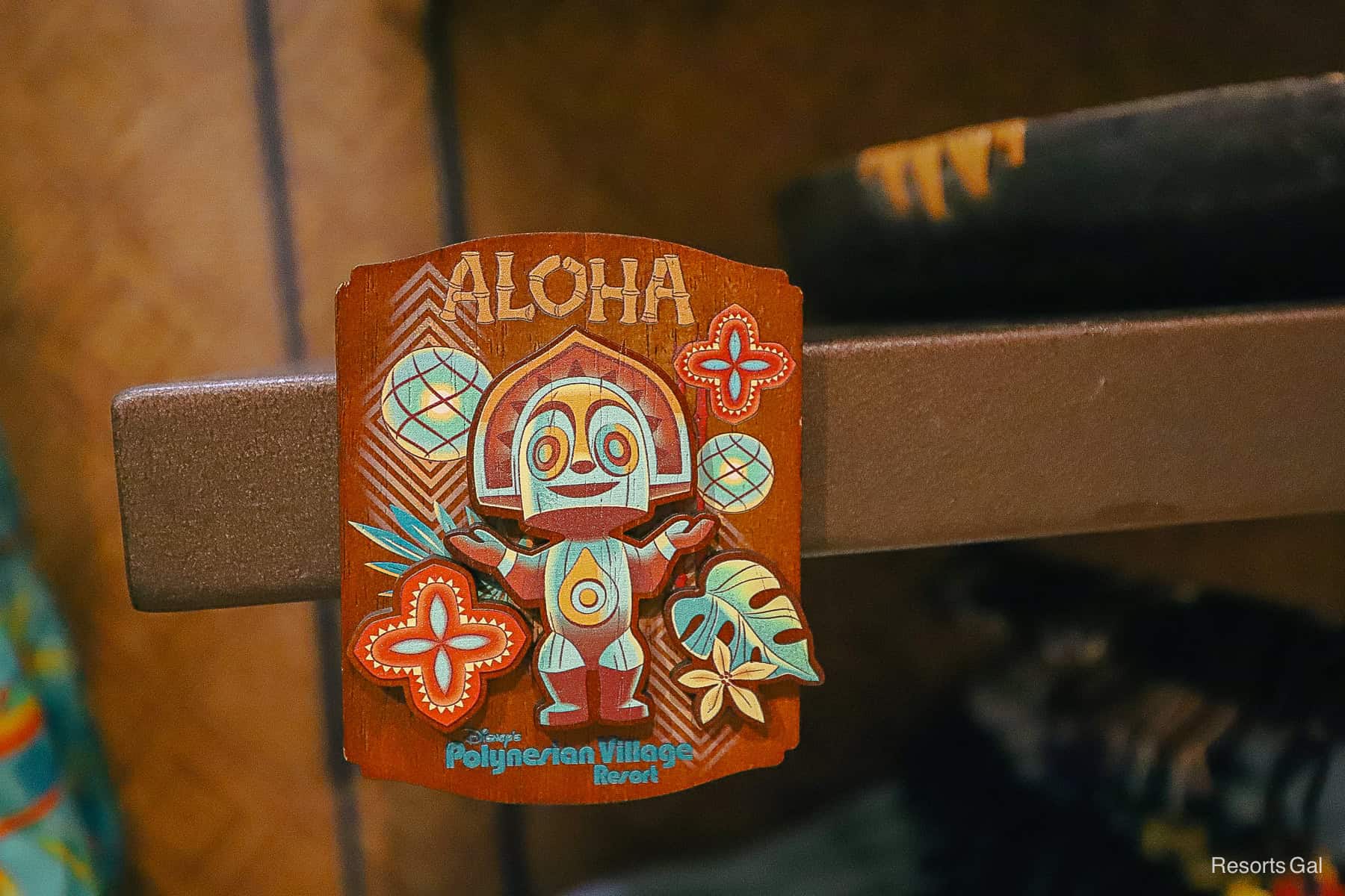 a magnet with a brown backdrop that says Aloha and features a tiki statue and the branded Disney Polynesian logo 