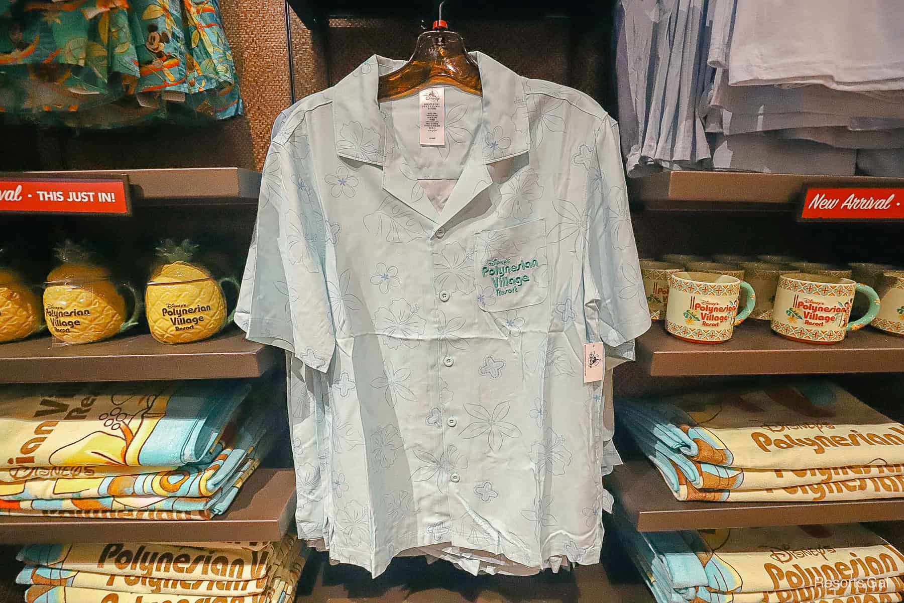 a button up men's shirt in light blue with Disney's Polynesian Village Resort logo 