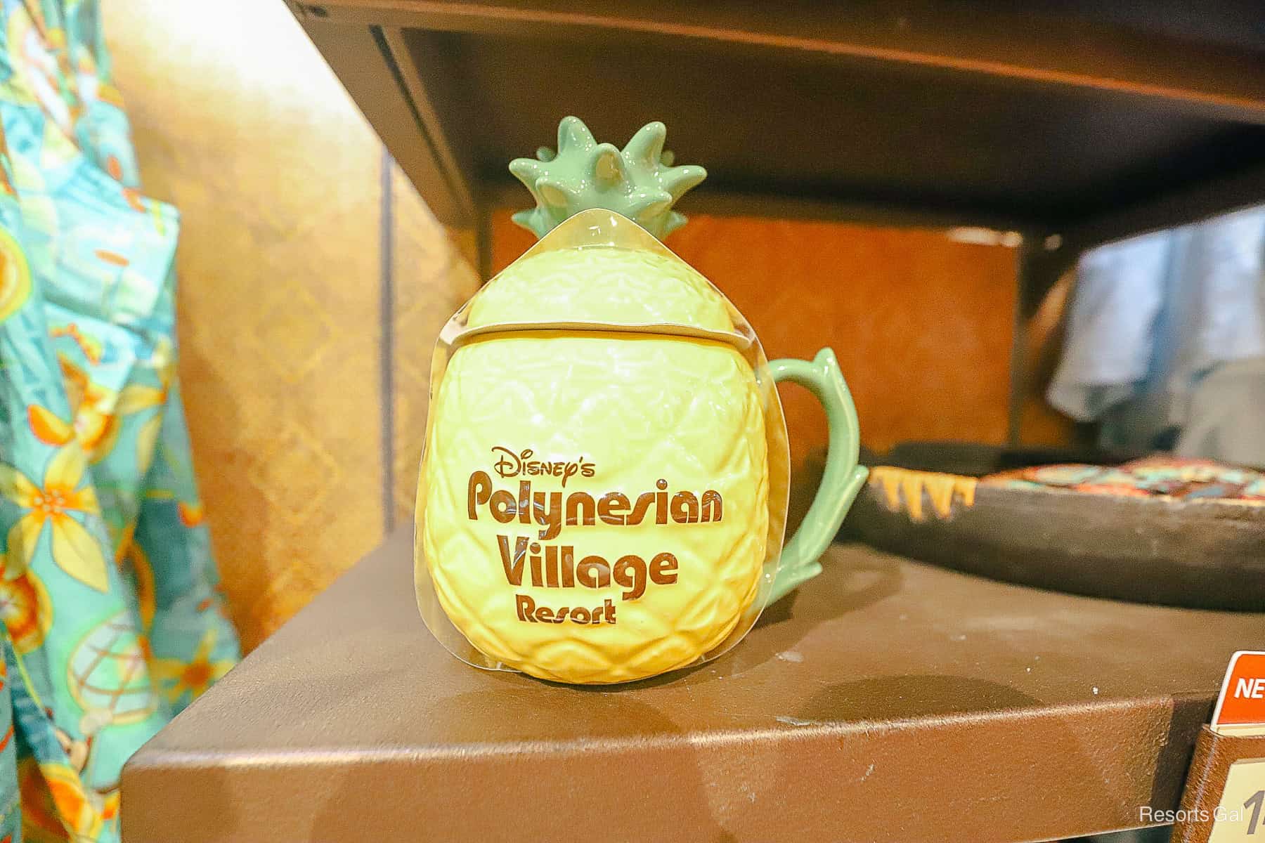 Disney's Polynesian Village Resort mug with lid in a pineapple shape with yellow, green, and brown colors 