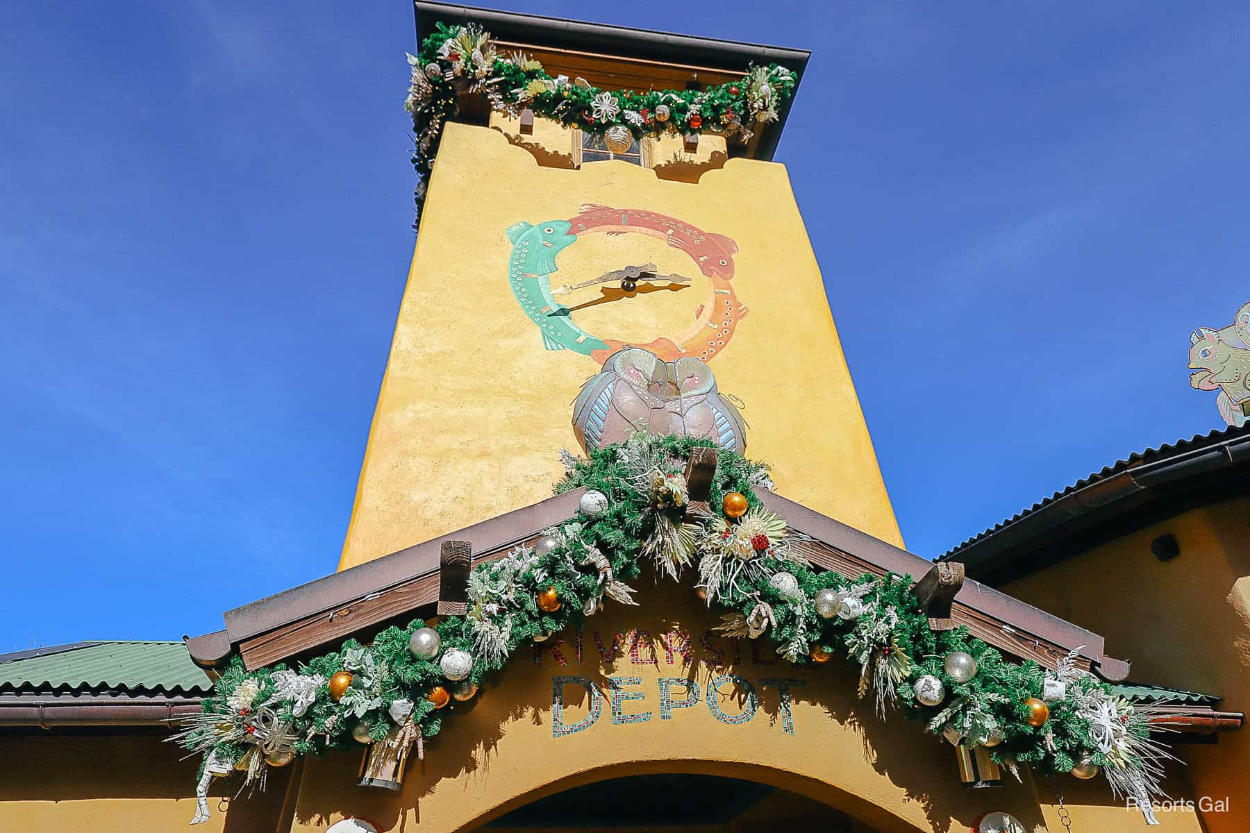 two birds keep each other warm underneath the clock