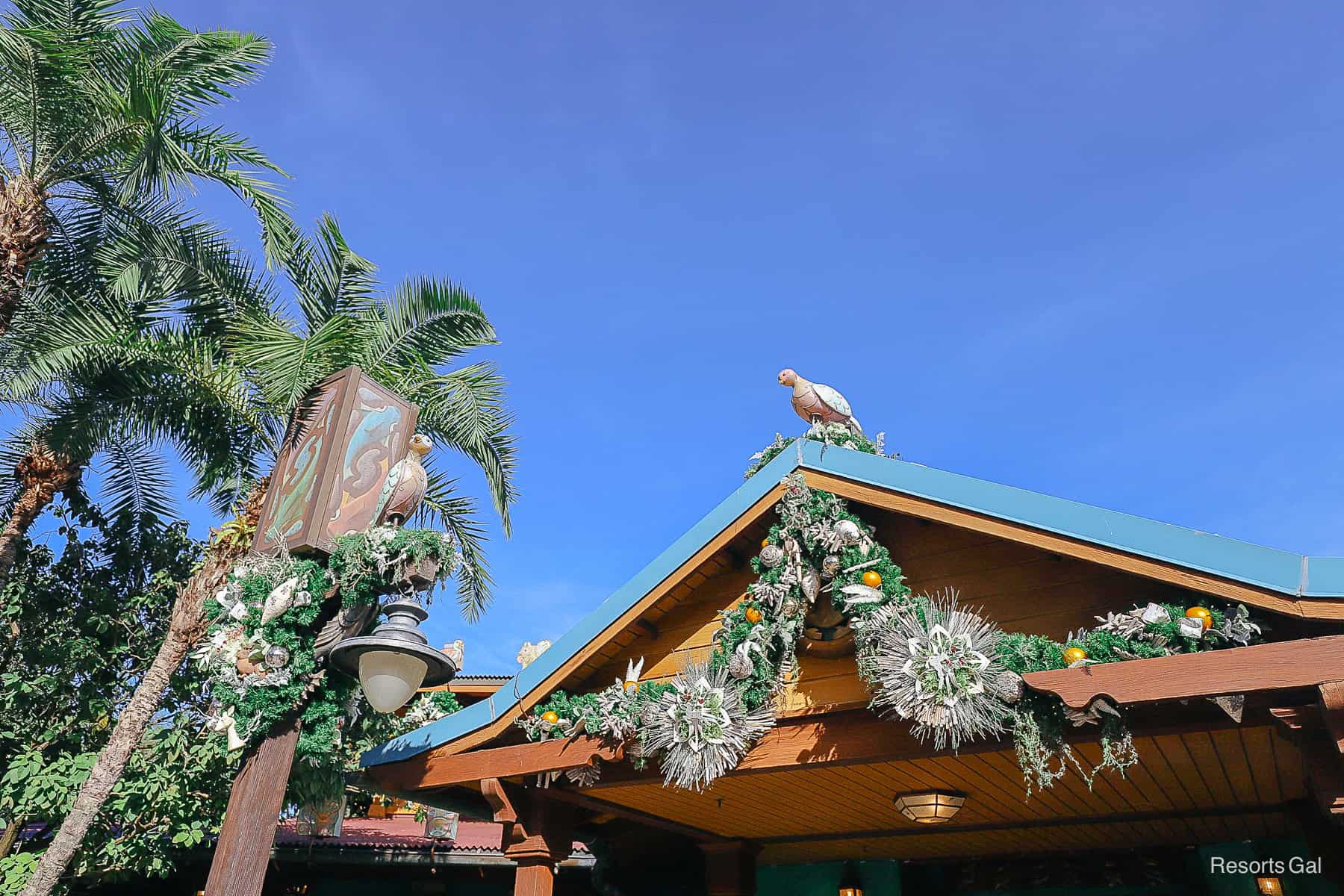 Christmas birds perched on the gift shops roofline with festive garland