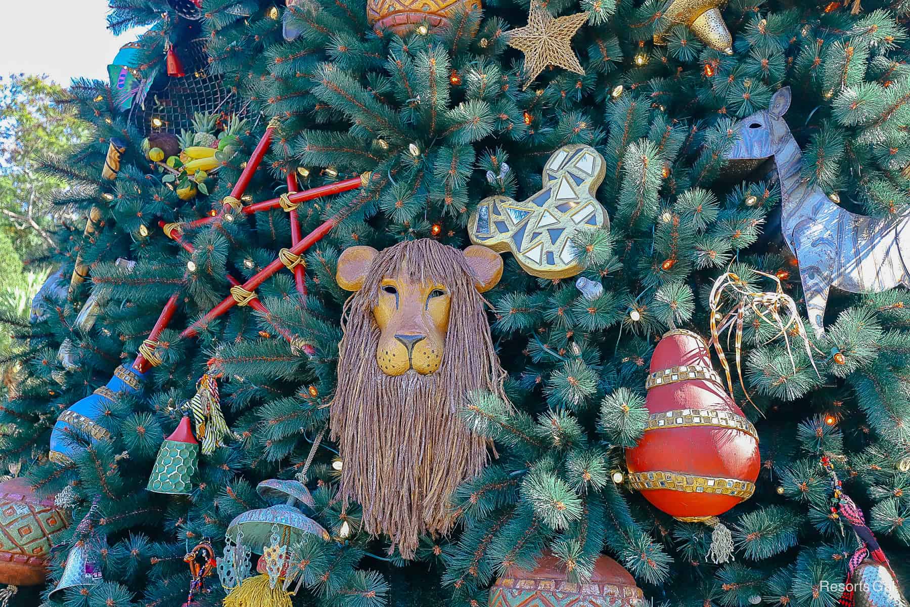 a closeup of a lion mask and a hidden Mickey on the Animal Kingdom Christmas Tree