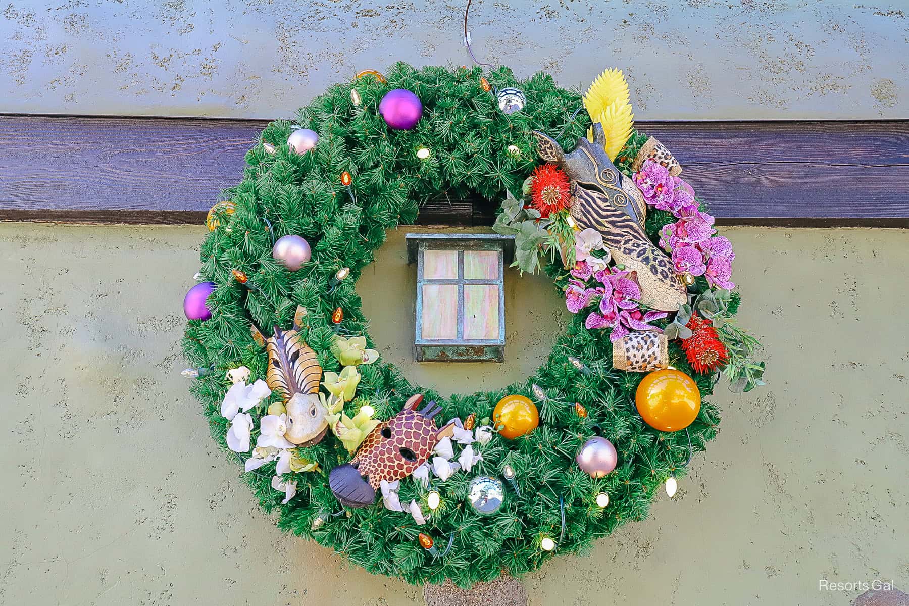 a wreath with animal masks, florals, and ornaments