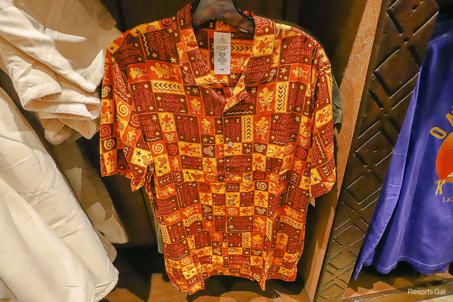 a button up print shirt with colors and the resort's logo 