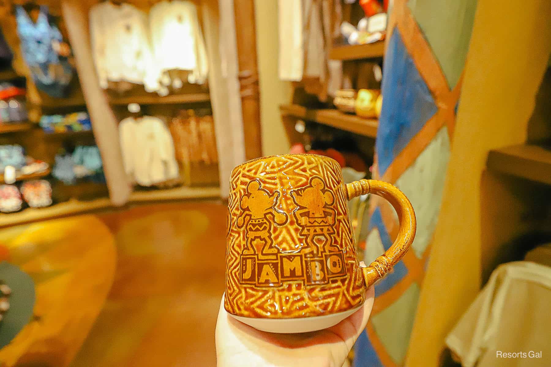 a coffee cup with Mickey and Minnie silhouettes with the word Jambo printed on it 