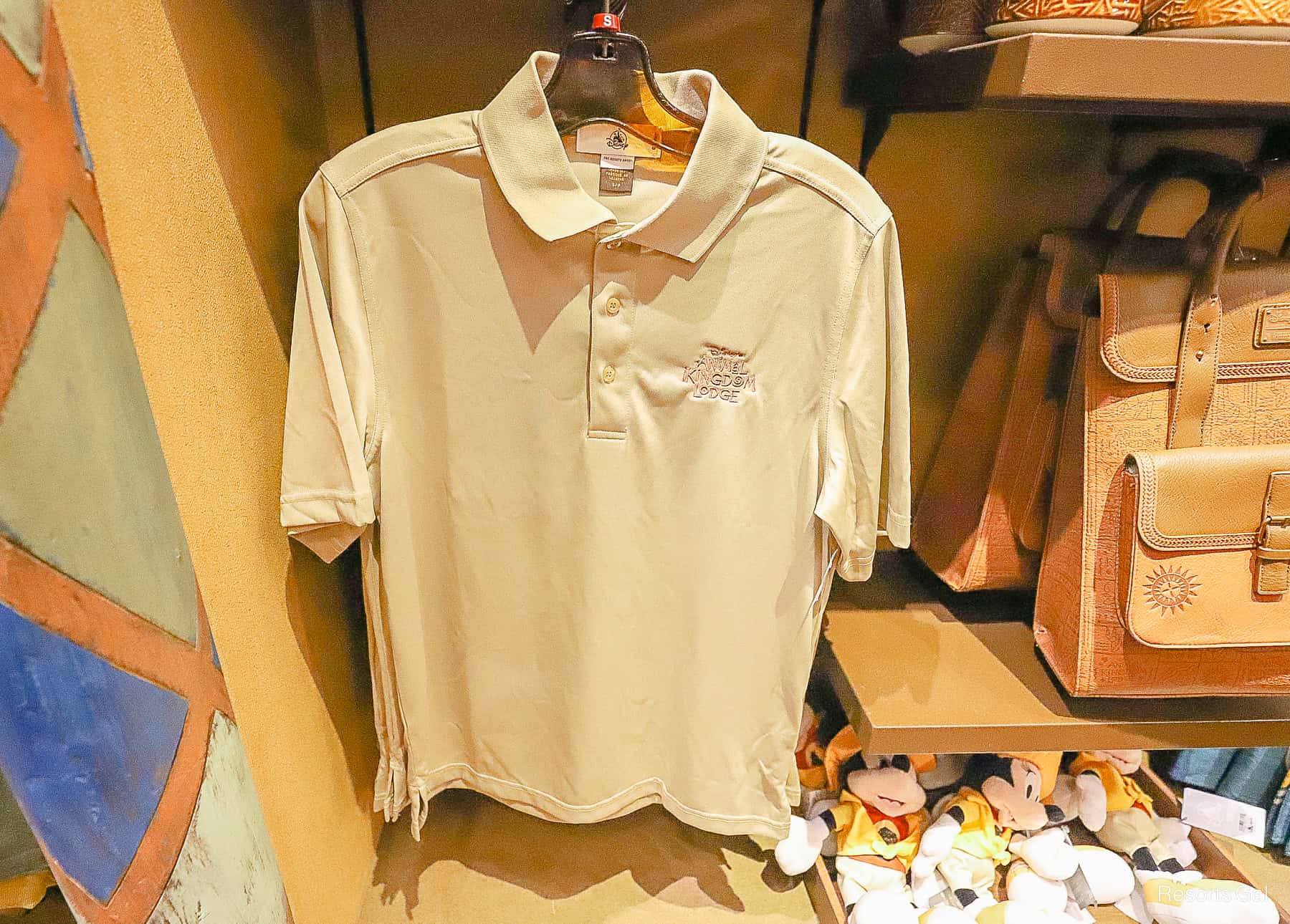 a tan polo shirt with the Animal Kingdom Lodge logo 