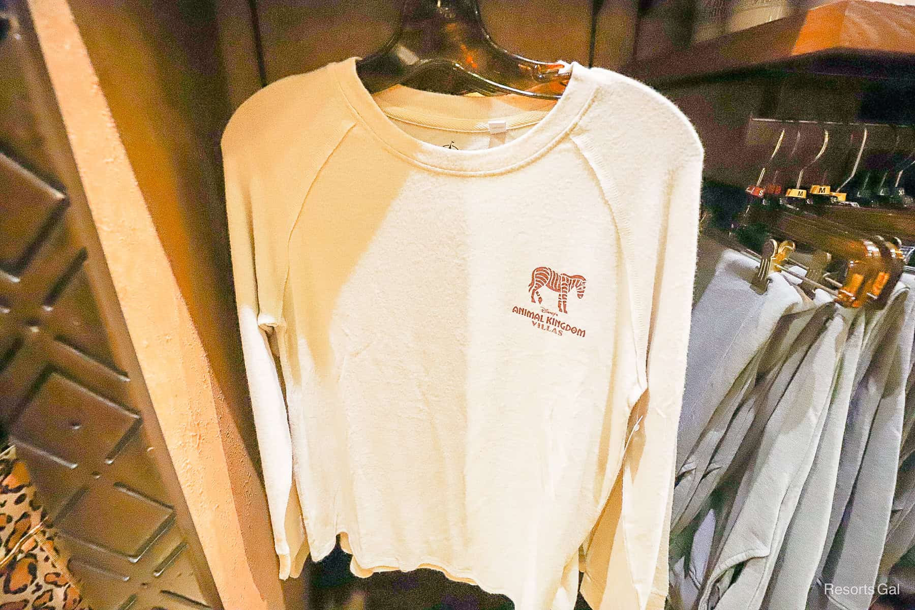 a white Animal Kingdom Villas sweatshirt with a zebra and DVC logo 