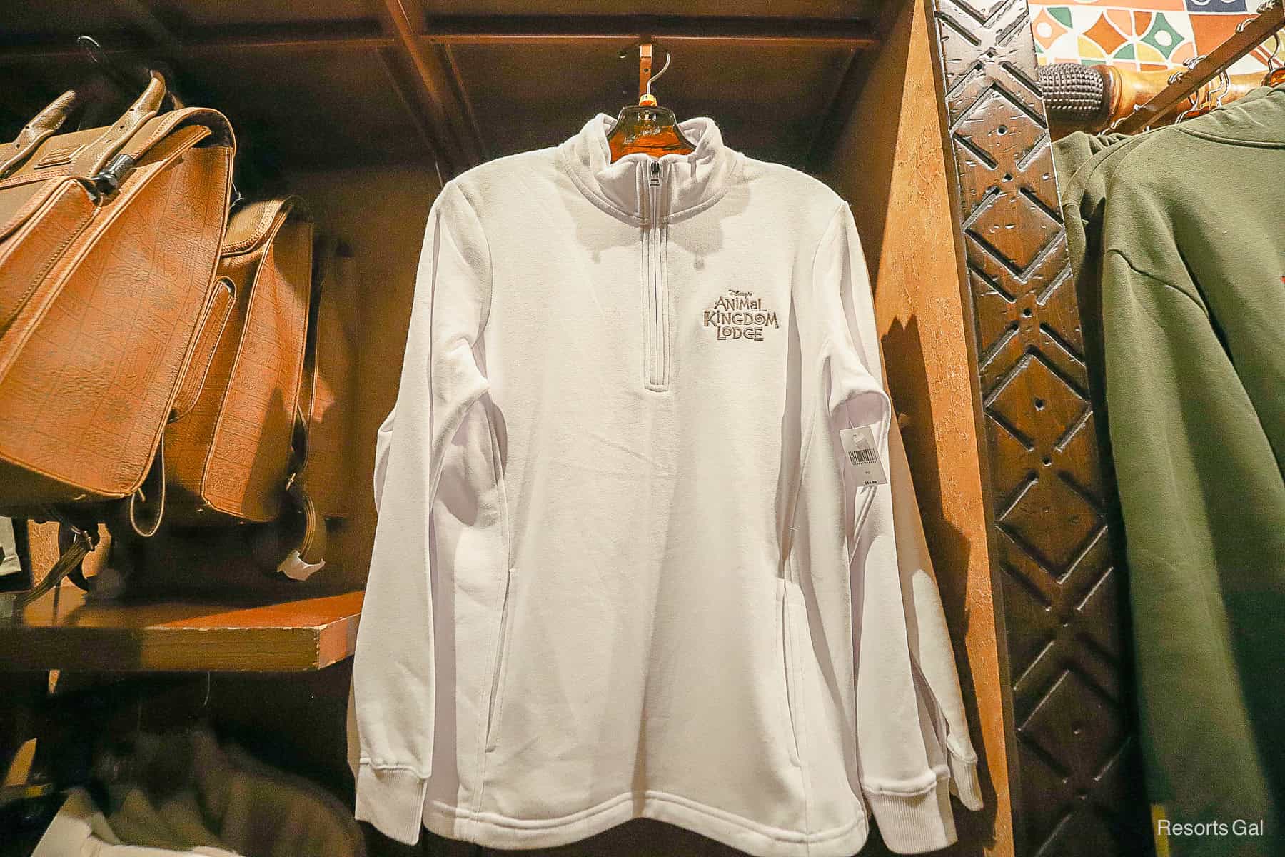 a white partial zip up pull over with the Disney's Animal Kingdom Lodge logo 