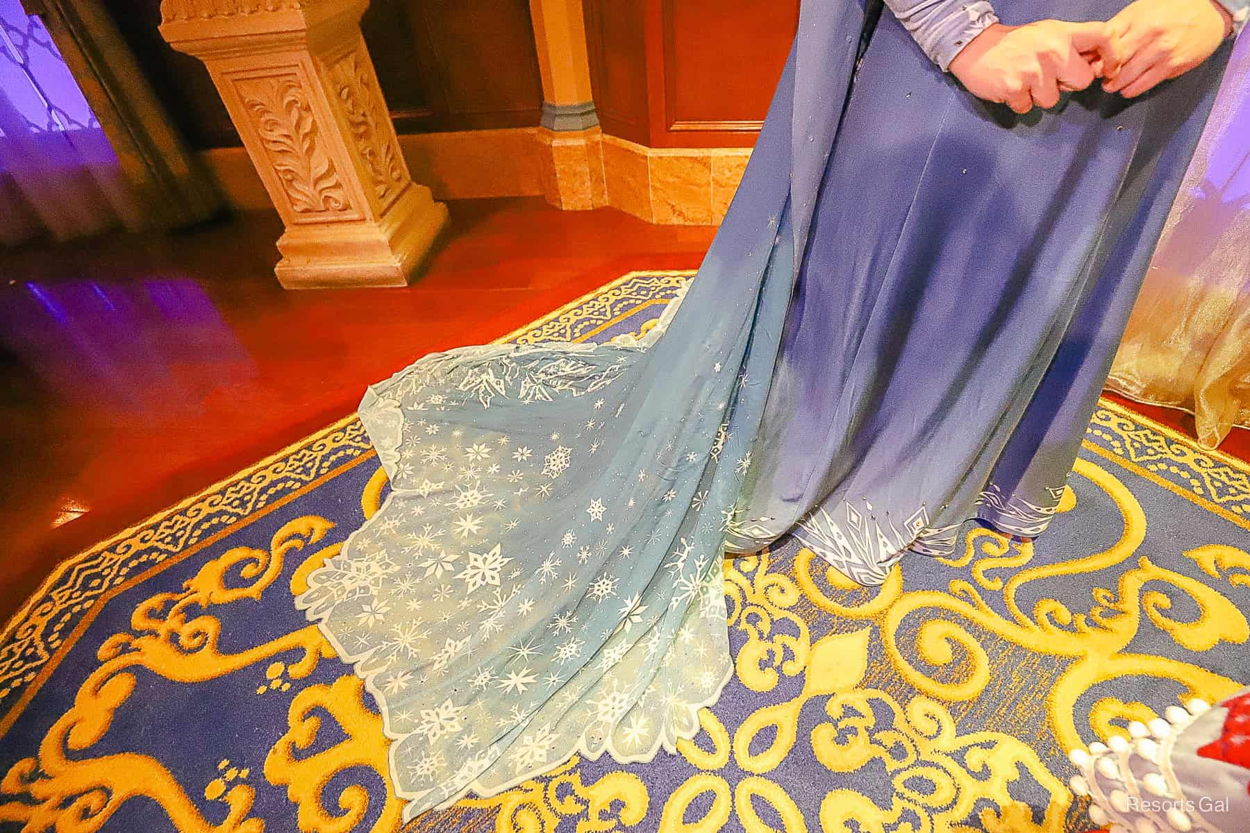 a close look at the train of Elsa'a dress that's trimmed with snowflakes 